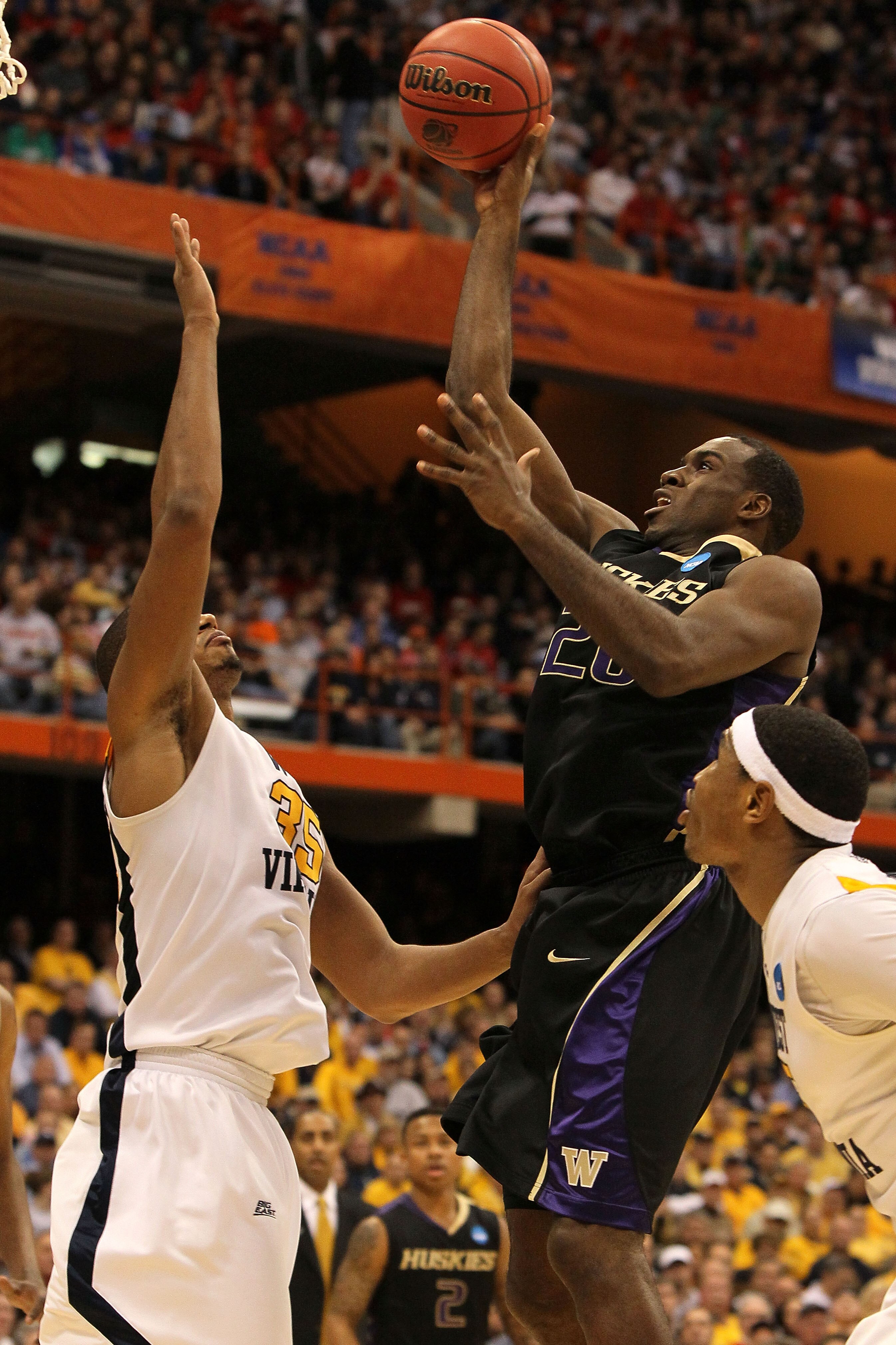 SYRACUSE, NY - MARCH 25:  Quincy Pondexter #20 of the Washington Huskies attempts a shot against Wellington Smith #35 of the West Virginia Mountaineers during the east regional semifinal of the 2010 NCAA men's basketball tournament at the Carrier Dome on
