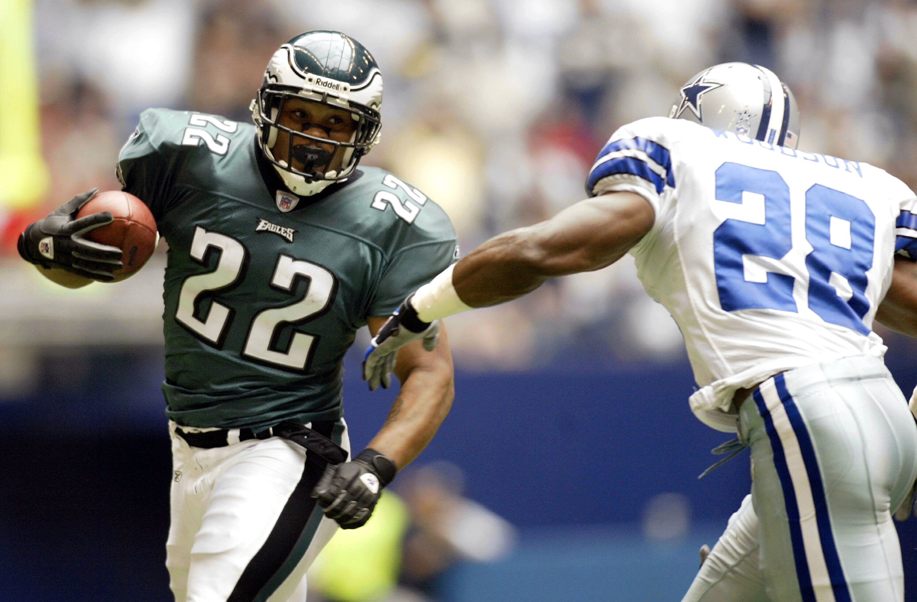 IRVING, TX - OCTOBER 12:  Running back Duce Staley #22 of the Philadelphia Eagles runs the ball against Darren Woodson #28 of the Dallas Cowboys at Texas Stadium on October 12, 2003 in Irving, Texas. The Cowboys defeated the Eagles 23-21.  (Photo by Ronal