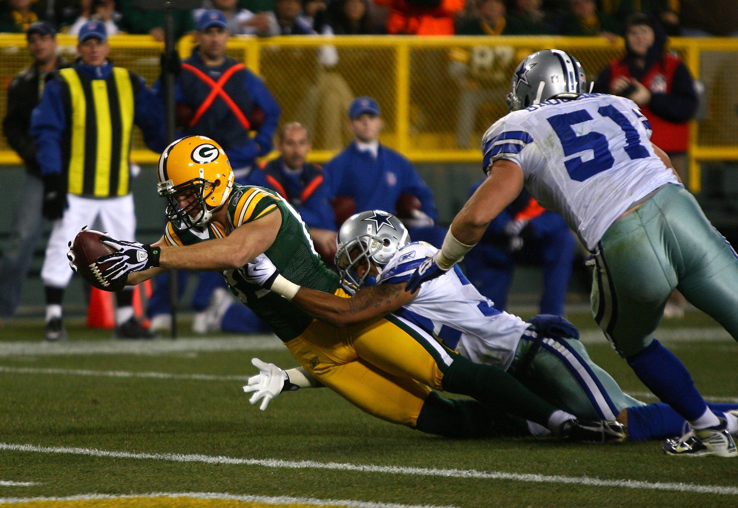 GREEN BAY, WI - NOVEMBER 15: Jordy Nelson #87 of the Green Bay Packers tries unsuccessfully to stretch the ball over the goal line as he's tackled by Orlando Scandrick #32 and Keith Booking #51 of the Dallas Cowboys at Lambeau Field on November 15, 2009 i