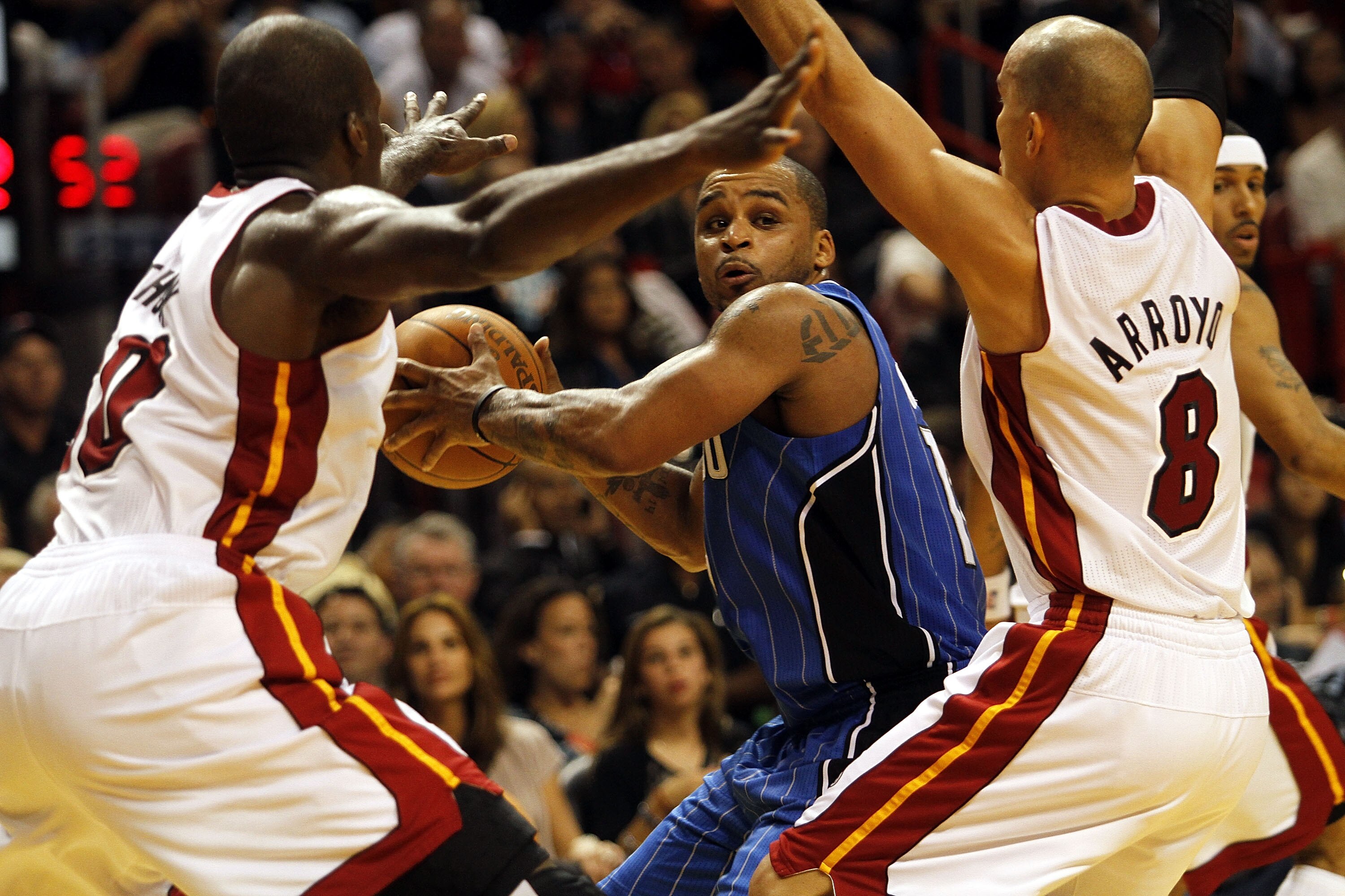 MIAMI - OCTOBER 29:  Guard Jameer Nelson #14 of the Orlando Magicis defended by guard Carlos Arroyo #8 and center Joel Anthony #50 of the Miami Heat at American Airlines Arena on October 29, 2010 in Miami, Florida.  NOTE TO USER: User expressly acknowledg