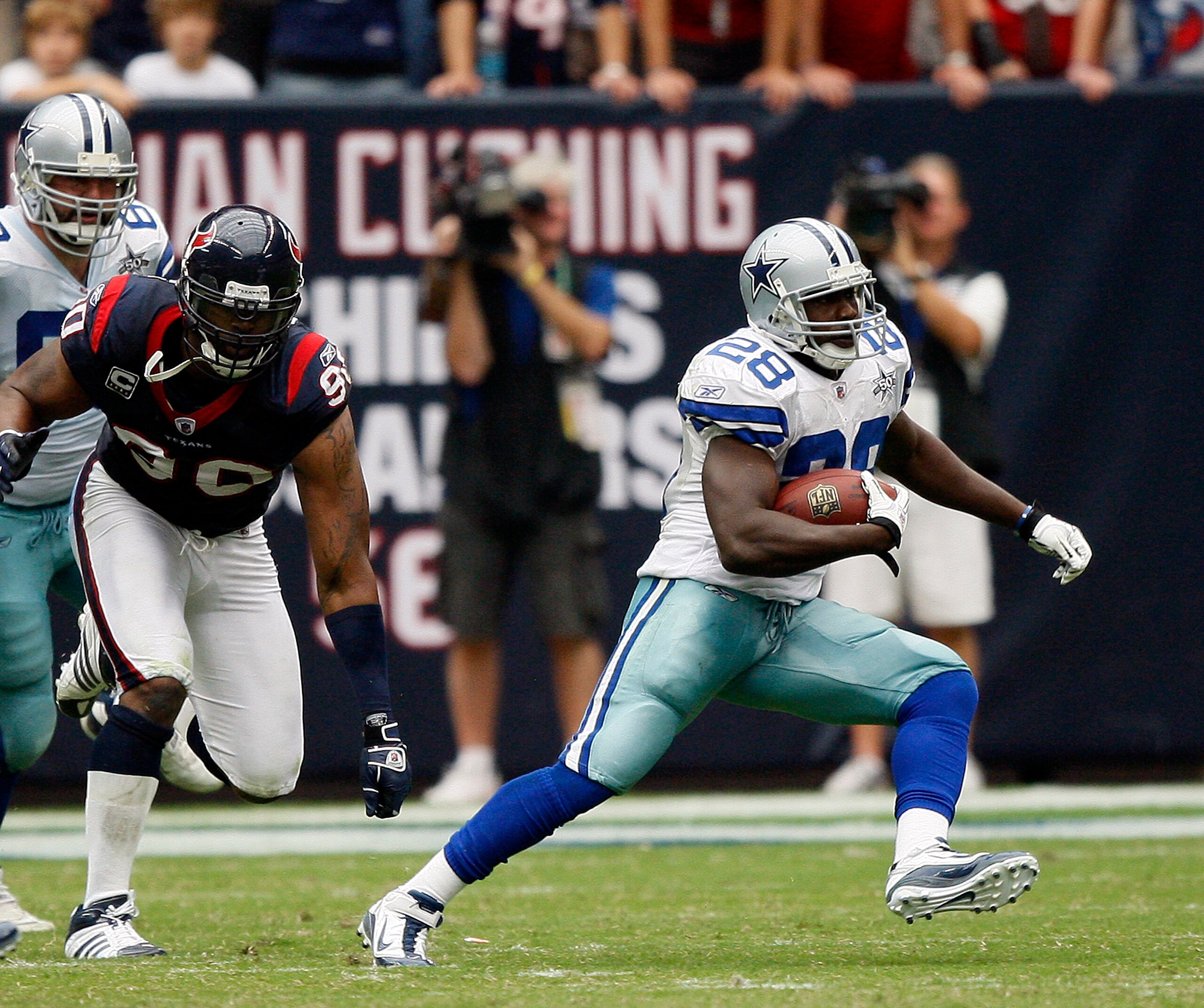 HOUSTON - SEPTEMBER 26:  Running back Felix Jones #28 of the Dallas Cowboys rushes past defensive end Mario Williams #90 of Houston Texans at Reliant Stadium on September 26, 2010 in Houston, Texas.  (Photo by Bob Levey/Getty Images)