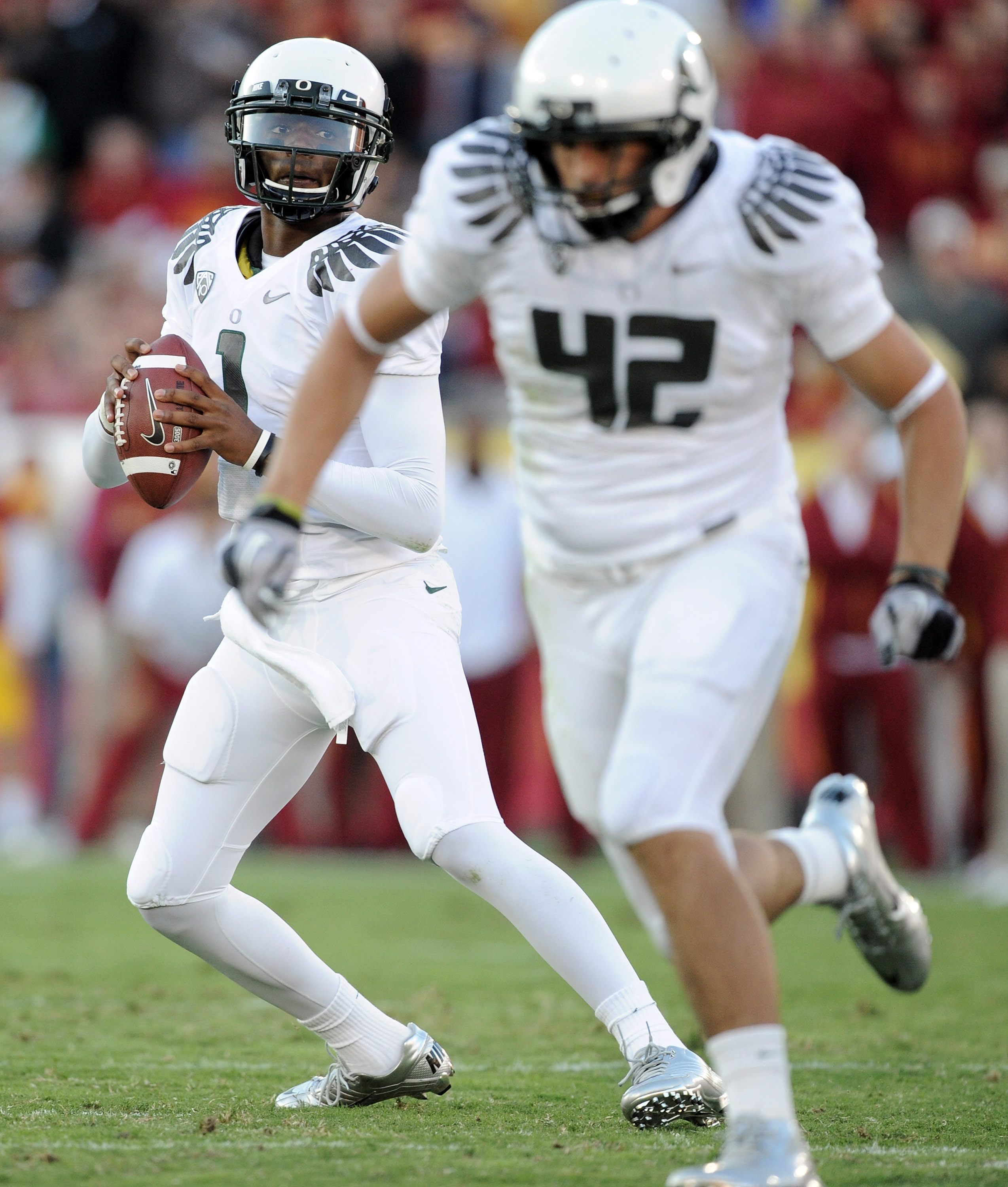 LOS ANGELES, CA - OCTOBER 30:  Darron Thomas #1 of the Oregon Ducks rolls out of the pocket behind David Paulson #42 against the USC Trojans during the game at Los Angeles Memorial Coliseum on October 30, 2010 in Los Angeles, California.  (Photo by Harry