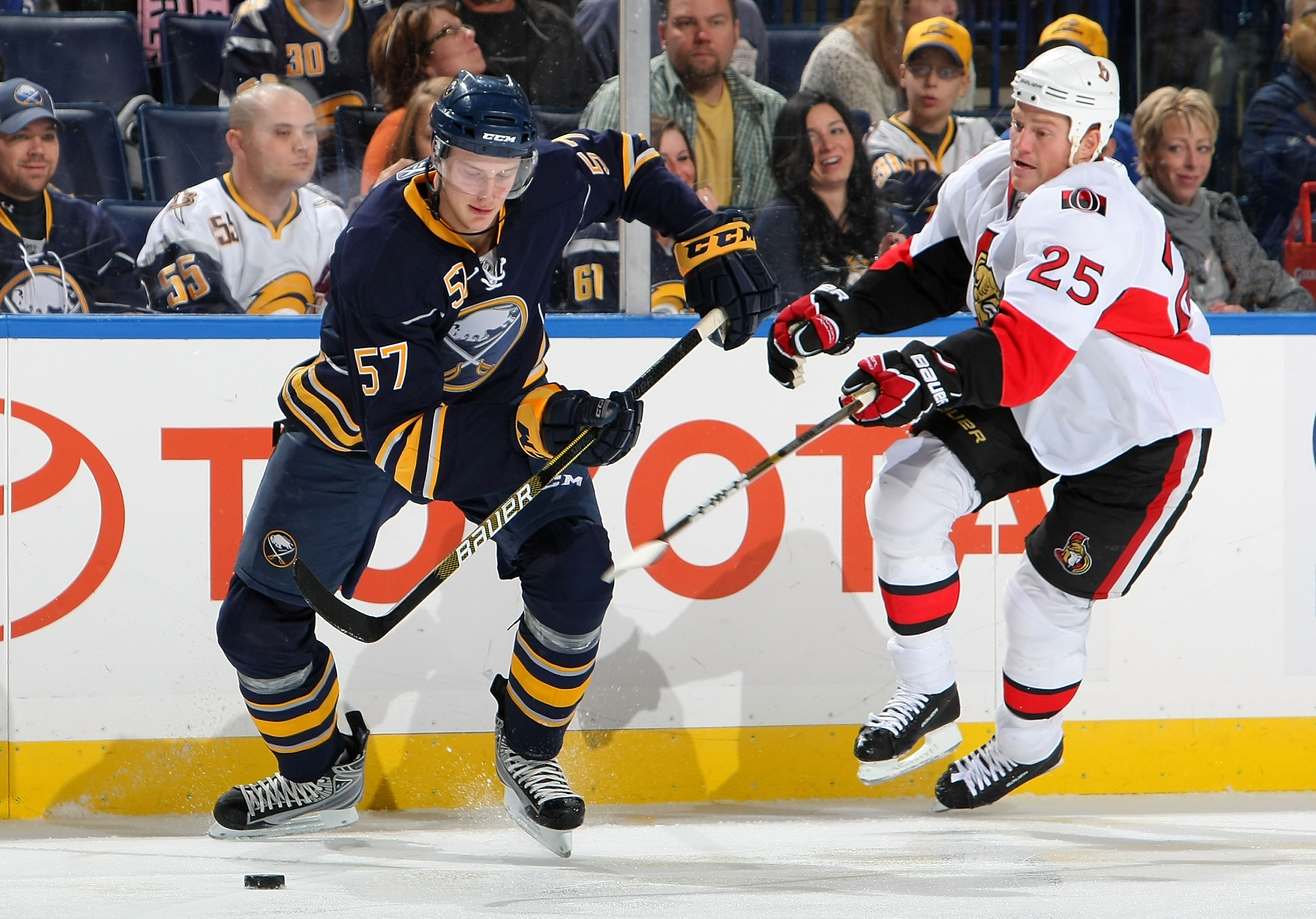BUFFALO - OCTOBER 22:  Tyler Myers #57 the Buffalo Sabres carries the puck as Chris Neil #25 of the Ottawa Senators keeps a close check during their NHL game at HSBC Arena October 22, 2010 in Buffalo, New York.(Photo By Dave Sandford/Getty Images)