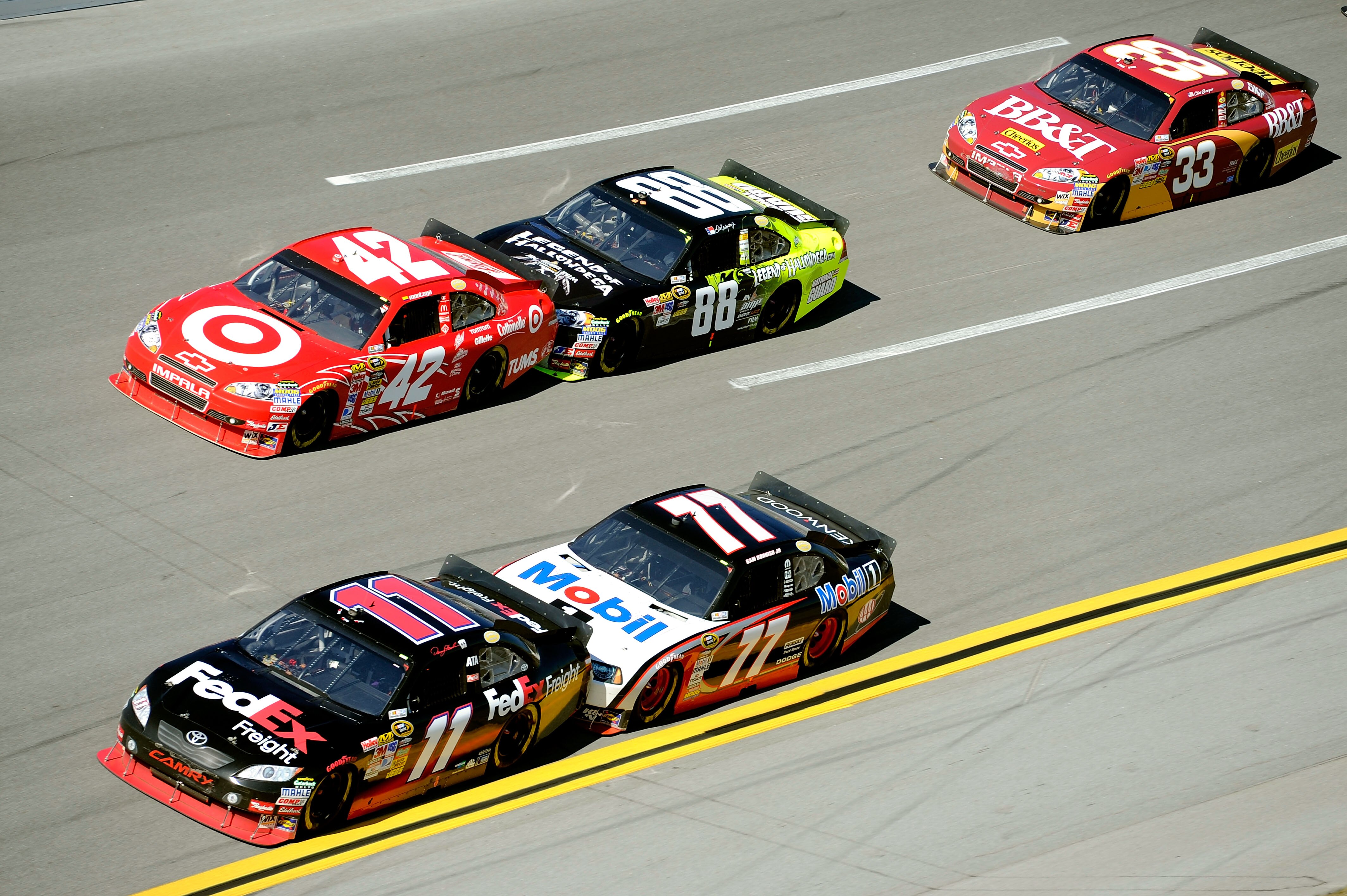 TALLADEGA, AL - OCTOBER 31:  Denny Hamlin, driver of the #11 FedEx Freight Toyota, and Juan Pablo Montoya, driver of the #42 Target Chevrolet, lead a group of cars during the NASCAR Sprint Cup Series AMP Energy Juice 500 at Talladega Superspeedway on Octo