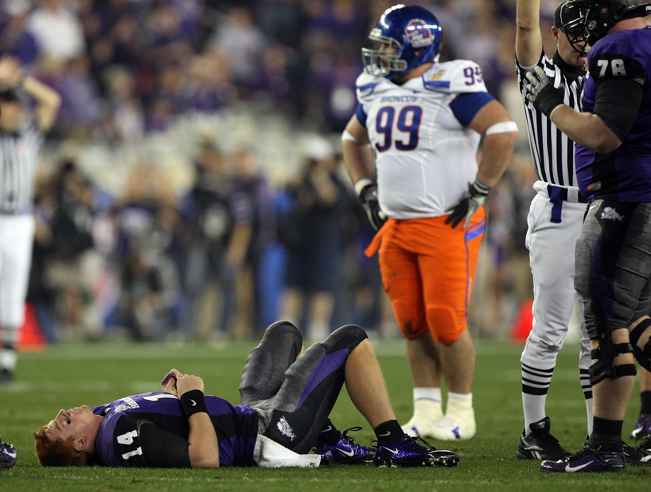 GLENDALE, AZ - JANUARY 04:  Quarterback Andy Dalton #14 of the TCU Horned Frogs lays on the ground injured after getting sacked against the Boise State Broncos during the Tostitos Fiesta Bowl at the Universtity of Phoenix Stadium on January 4, 2010 in Gle