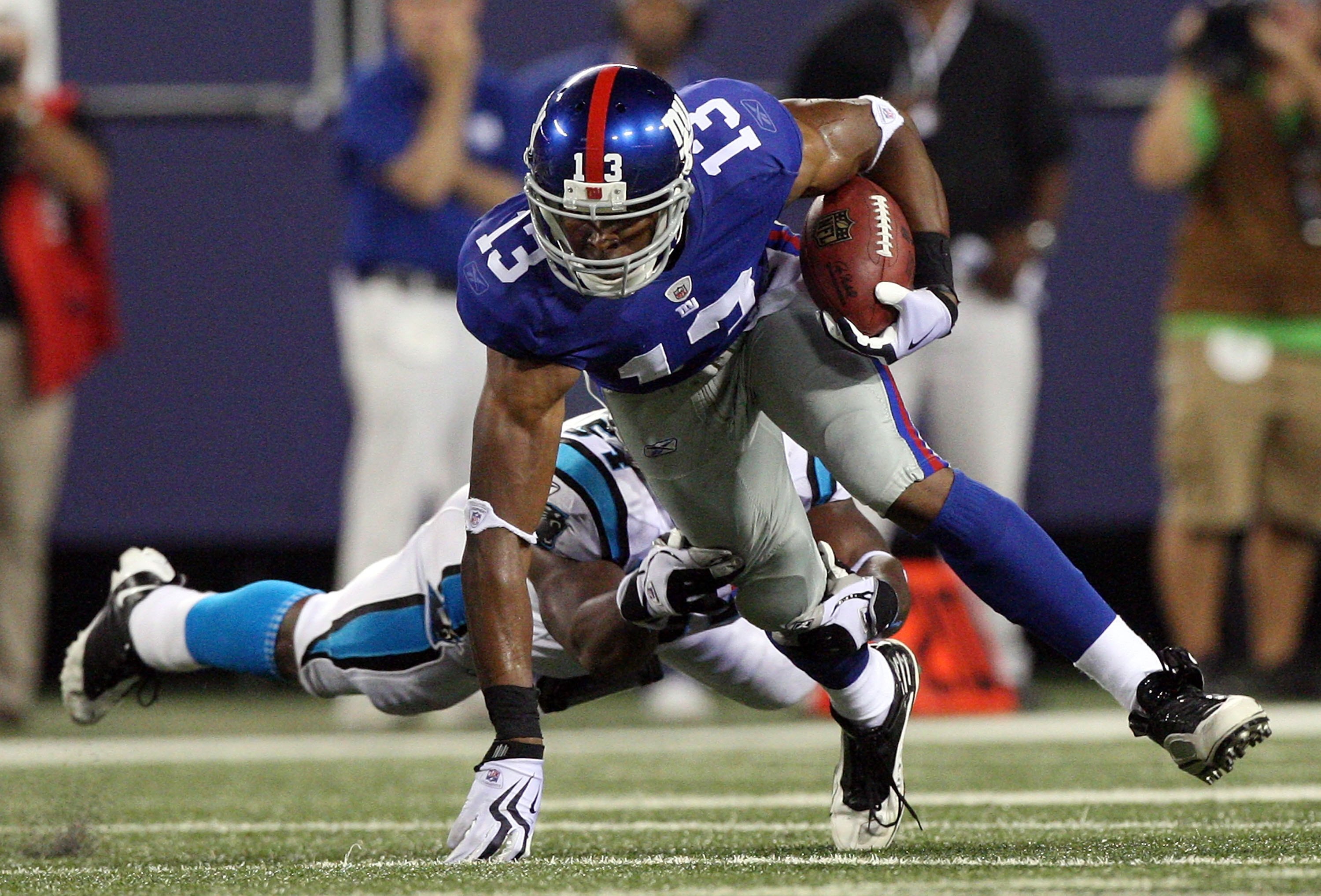EAST RUTHERFORD, NJ - AUGUST 17:  Ramses Barden #13 of the New York Giants runs the ball past the tackle attempt from Mortty Ivy #54 of the Carolina Panthers on August 17, 2009 at Giants Stadium in East Rutherford, New Jersey. The Giants defeated the Pant