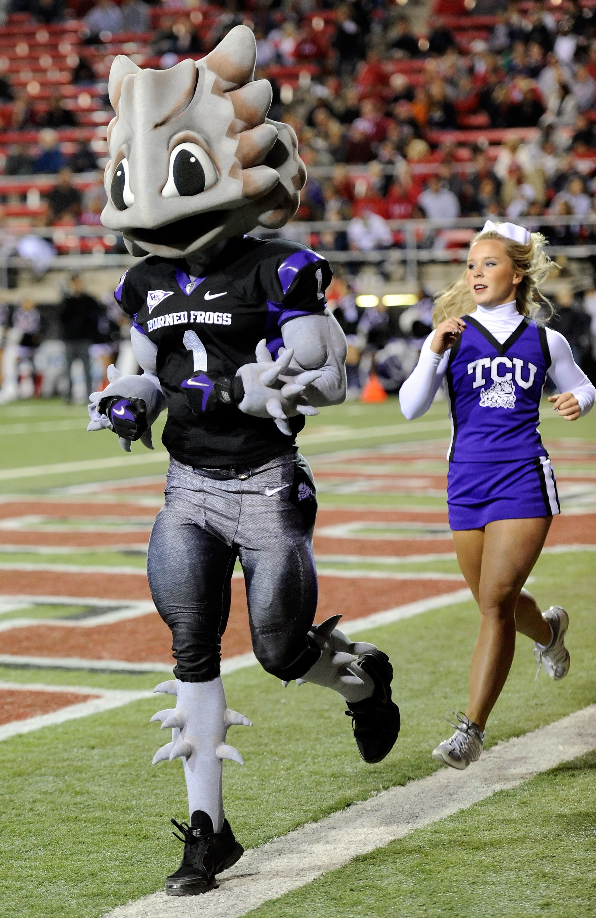 LAS VEGAS - OCTOBER 30: Texas Christian University Horned Frogs mascot 'Superfrog' and a cheerleader run along the end zone after the team scored against the UNLV Rebels at Sam Boyd Stadium October 30, 2010 in Las Vegas, Nevada. TCU won 48-6. (Photo by LAS VEGAS - OCTOBER 30: Texas Christian University Horned Frogs mascot 'Superfrog' and a cheerleader run along the end zone after the team scored against the UNLV Rebels at Sam Boyd Stadium October 30, 2010 in Las Vegas, Nevada. TCU won 48-6. (Photo by