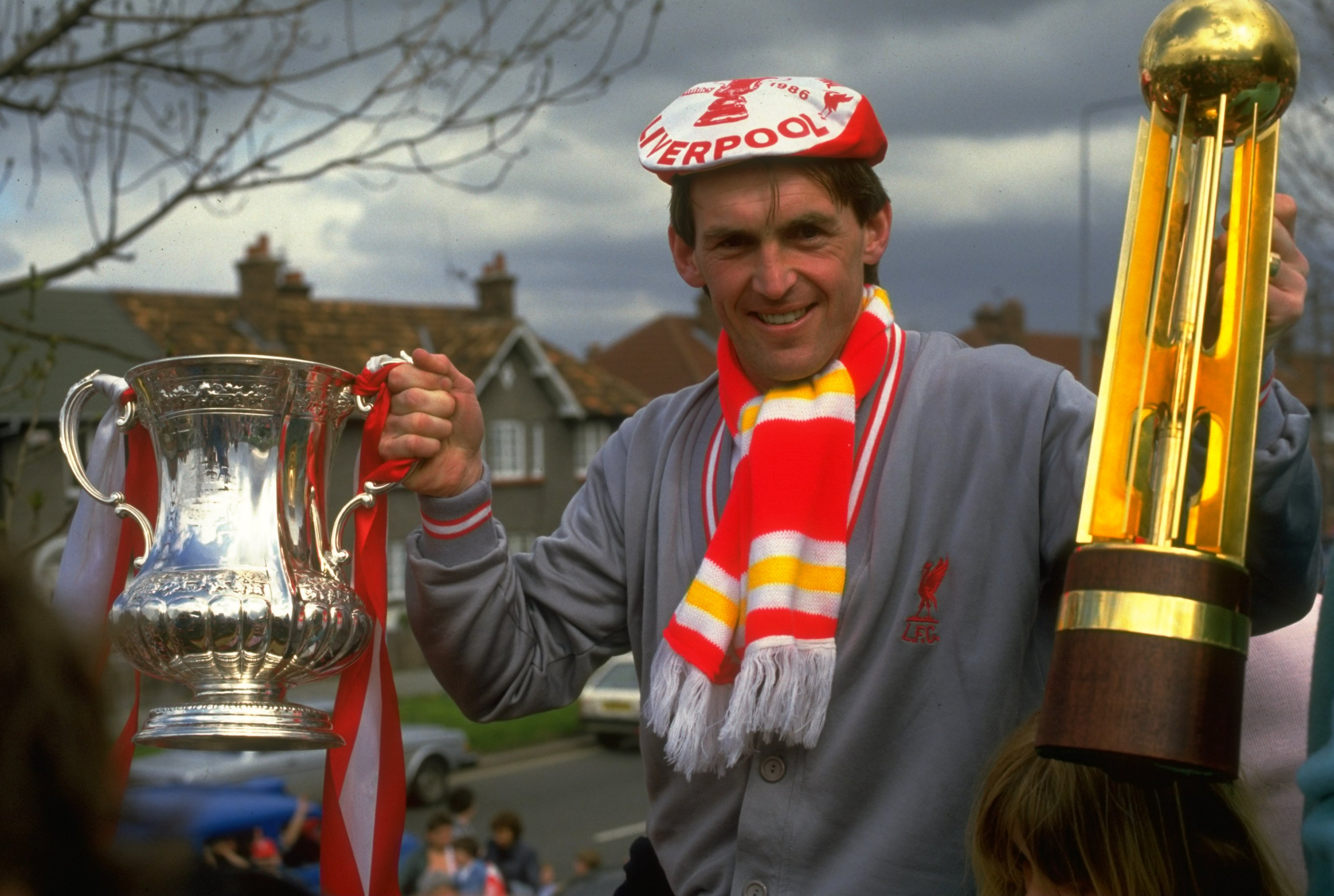 1986:  Player/Manager Kenny Dalglish of Liverpool poses with the FA Cup and the Canon League Division One trophy during their homecoming after the FA Cup final against Everton at Wembley Stadium in London. Liverpool won the match 3-1 to gain a League andC