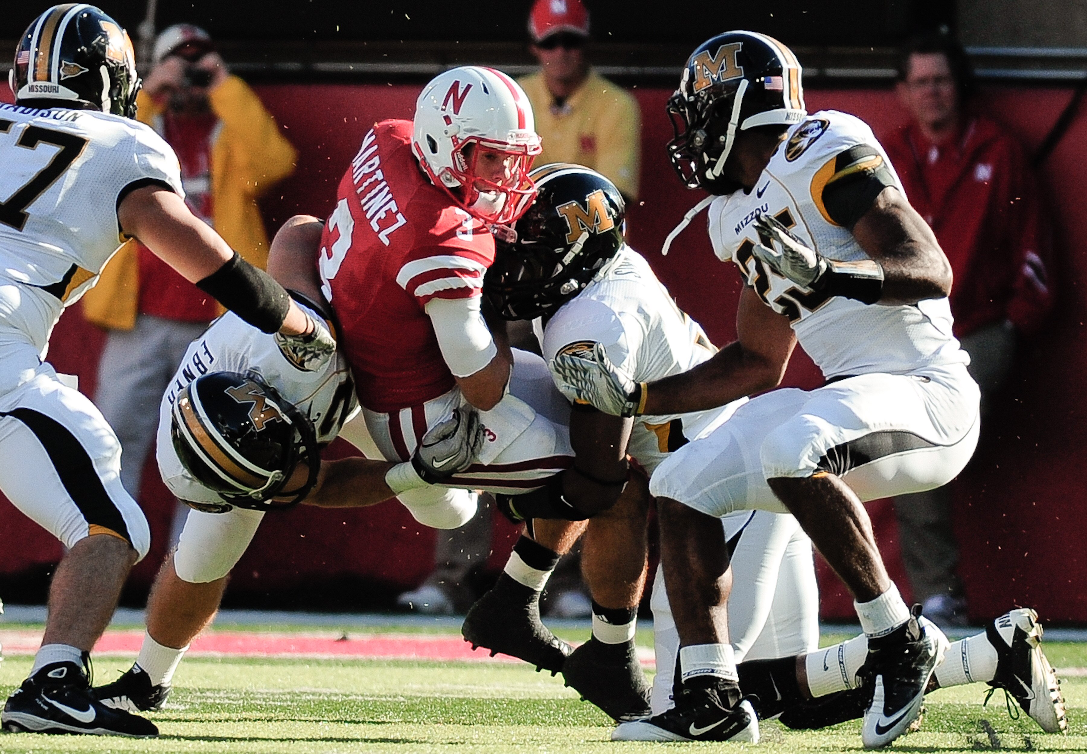 LINCOLN, NE - OCTOBER 30: Quarterback Taylor Martinez #3 of the Nebraska Cornhuskers tries to slip between Missouri Tiger defenders during first half action of their game at Memorial Stadium on October 30, 2010 in Lincoln, Nebraska. Nebraska Defeated Miss