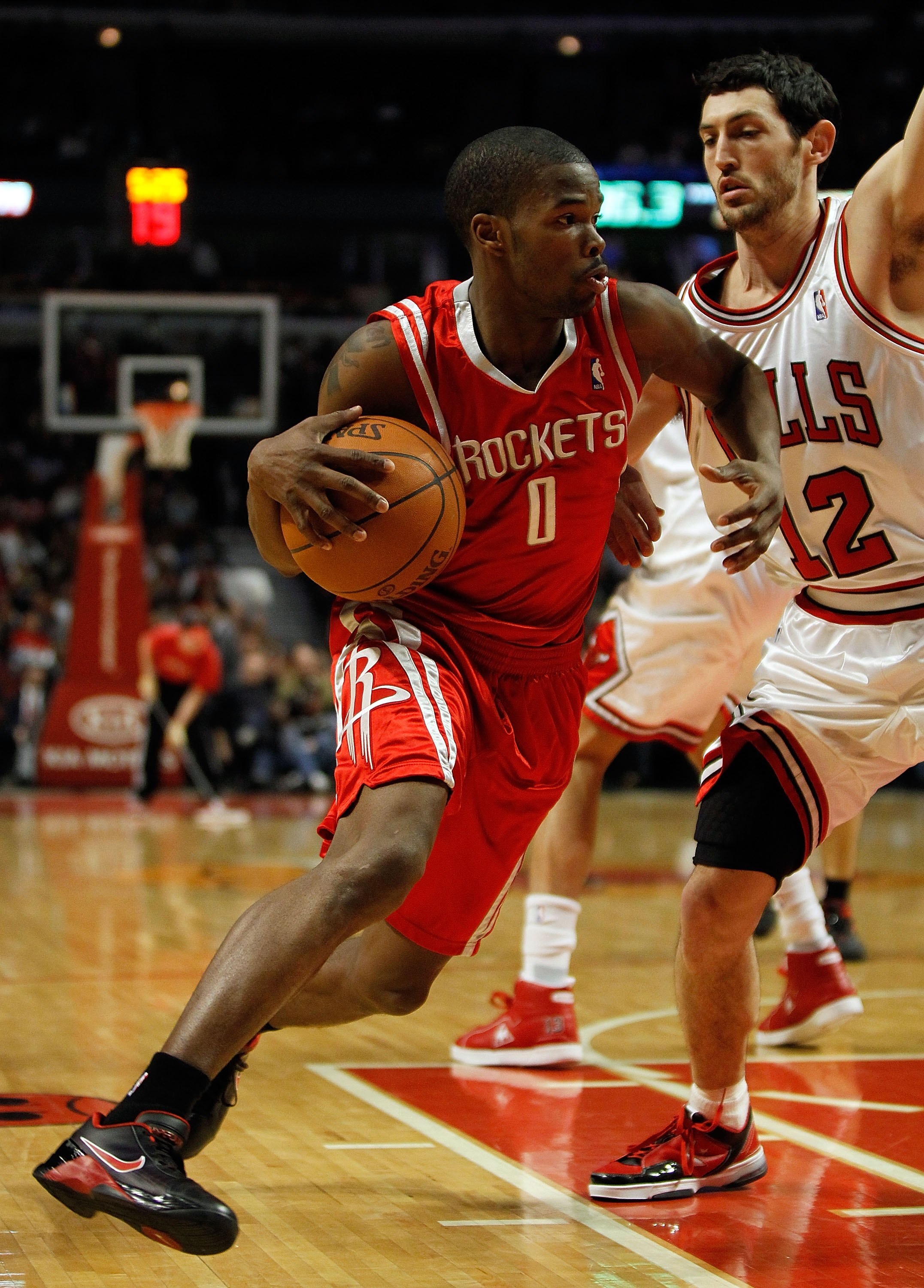 CHICAGO - MARCH 22: Aaron Brooks #0 of the Houston Rockets drives around Kirk Hinrich #12 of the Chicago Bulls at the United Center on March 22, 2010 in Chicago, Illinois. The Bulls defeated the Rockets 98-88. NOTE TO USER: User expressly acknowledges and