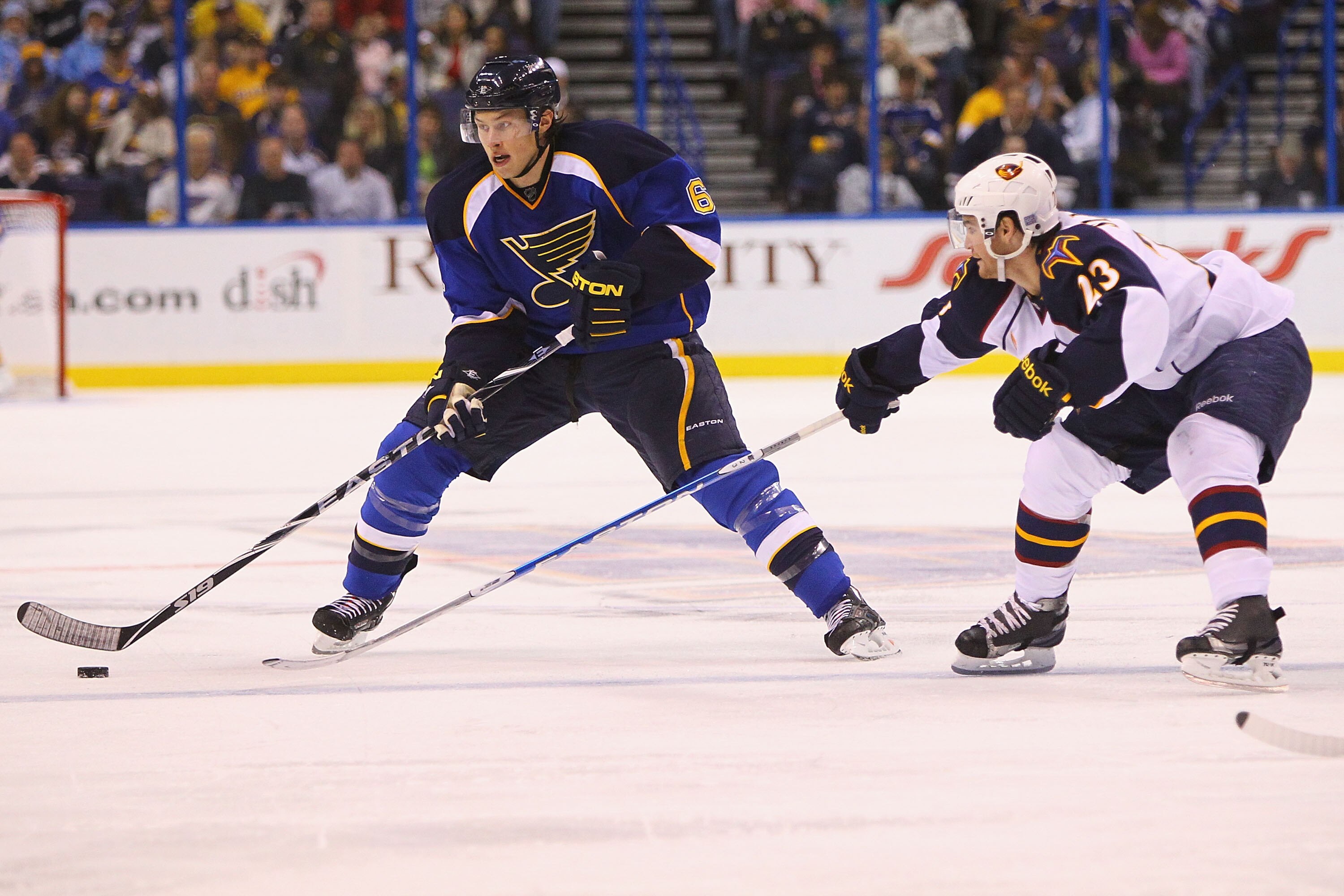 ST. LOUIS - OCTOBER 30: Erik Johnson #6 of the St. Louis Blues moves the puck up the ice against Jim Slater #23 of the Atlanta Thrashers at the Scottrade Center on October 30, 2010 in St. Louis, Missouri.  (Photo by Dilip Vishwanat/Getty Images)