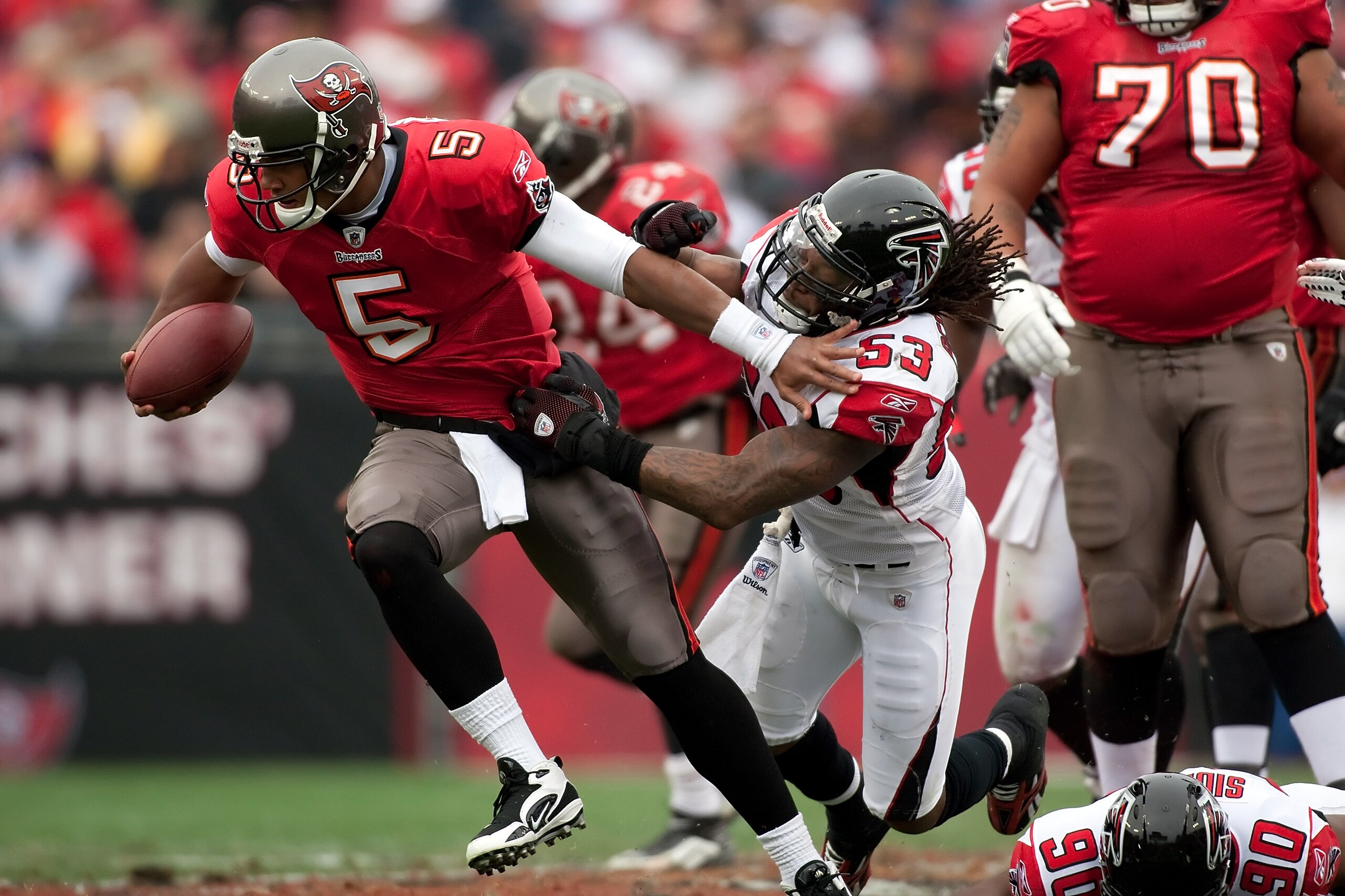 TAMPA, FL - JANUARY 03:  Quarterback Josh Freeman #5 of the Tampa Bay Buccaneers escapes the grasp of linebacker Mike Peterson #53 of the Atlanta Falcons during the game at Raymond James Stadium on January 3, 2010 in Tampa, Florida.  (Photo by J. Meric/Ge