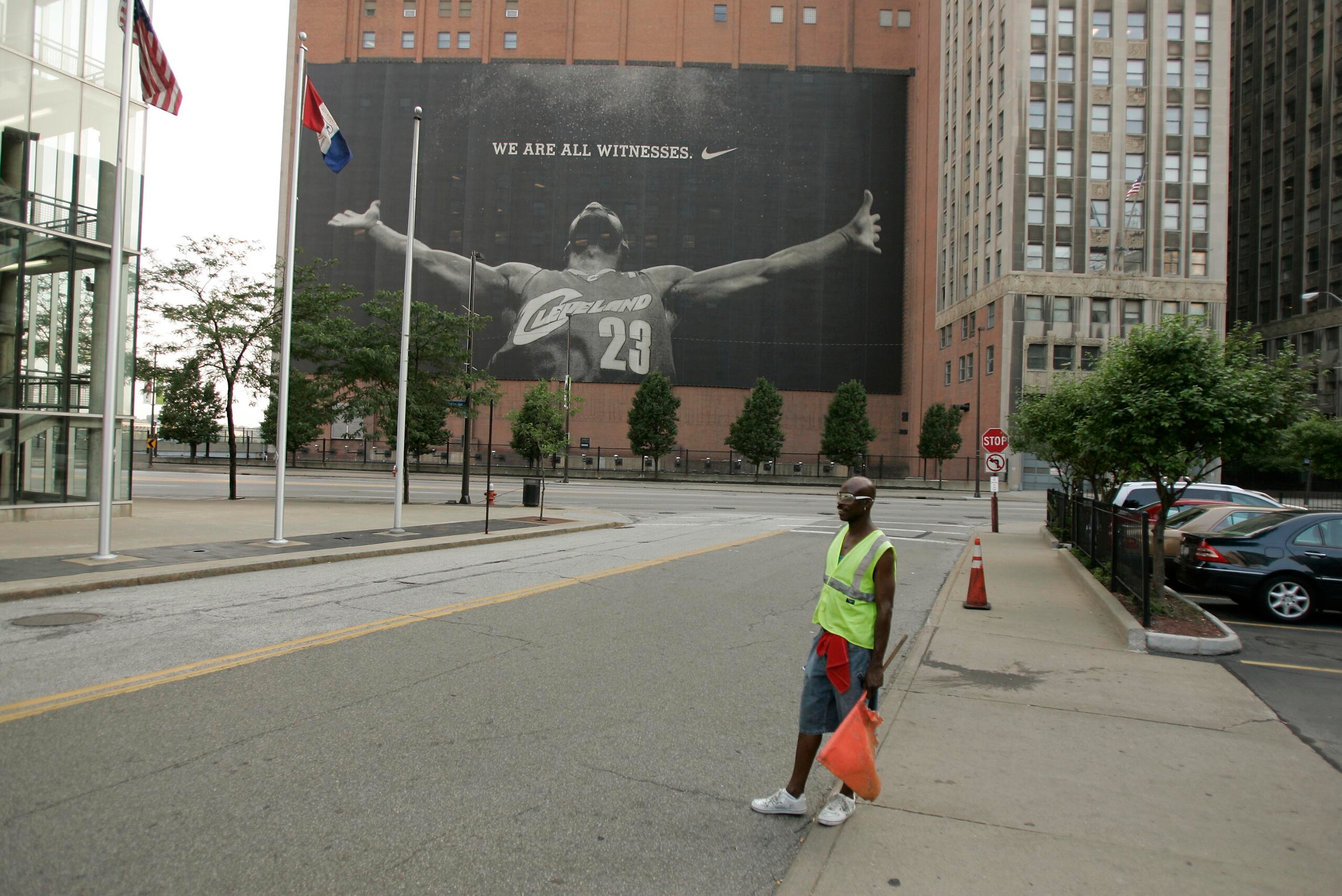 CLEVELAND - JULY 8:  A parking attendant stands near a larger than life photograph of LeBron James July 8, 2010 in Cleveland, Ohio. The two-time Most Valuable Player has the choice of remaining with the Cleveland Cavaliers or signing with a new team. (Pho