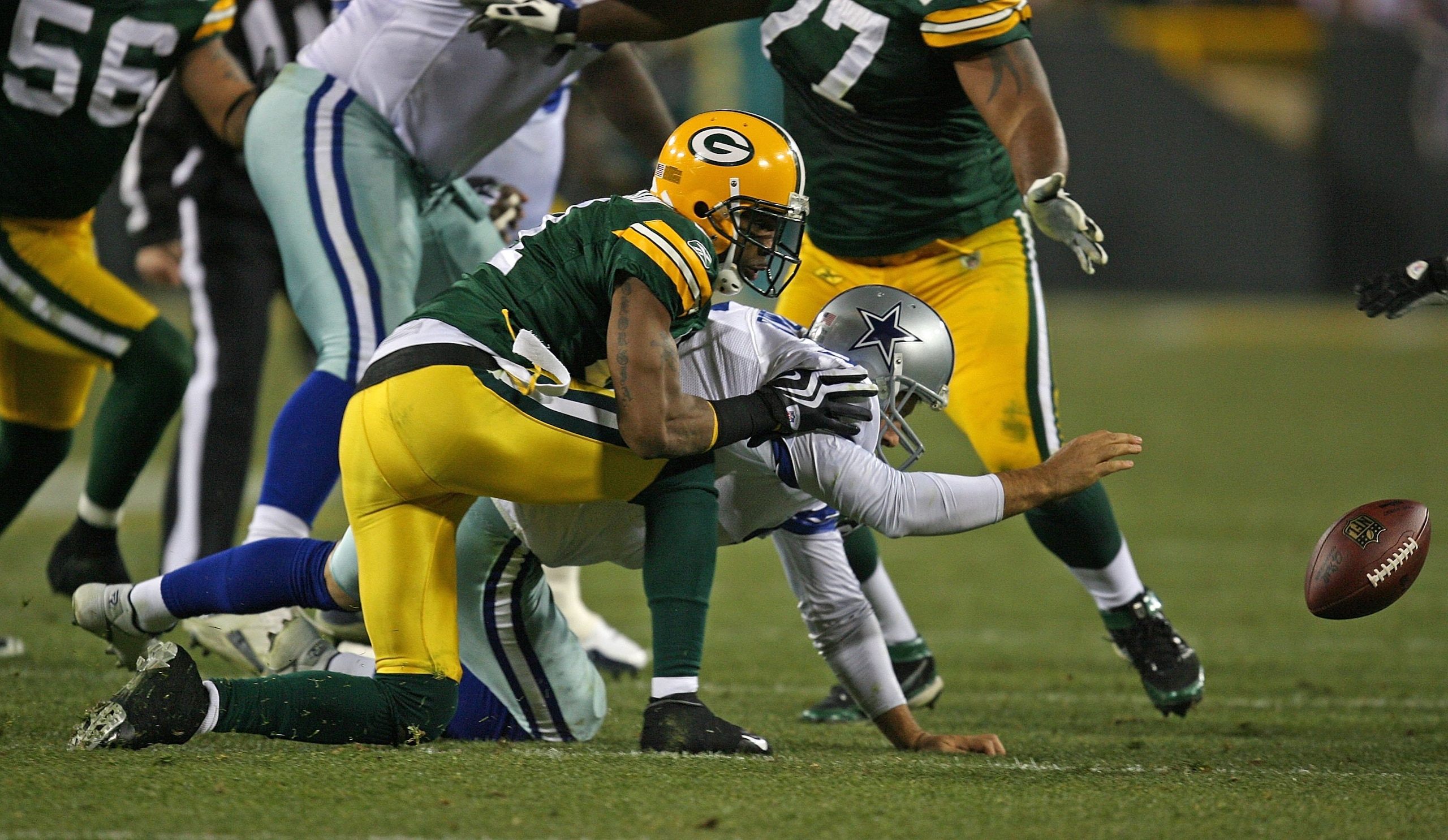 GREEN BAY, WI - NOVEMBER 15: Tony Romo #9 of the Dallas Cowboys reaches for the ball after fumbling while being sacked by Charles Woodson #21 of the Green Bay Packers at Lambeau Field on November 15, 2009 in Green Bay, Wisconsin. The Packers defeated the GREEN BAY, WI - NOVEMBER 15: Tony Romo #9 of the Dallas Cowboys reaches for the ball after fumbling while being sacked by Charles Woodson #21 of the Green Bay Packers at Lambeau Field on November 15, 2009 in Green Bay, Wisconsin. The Packers defeated the