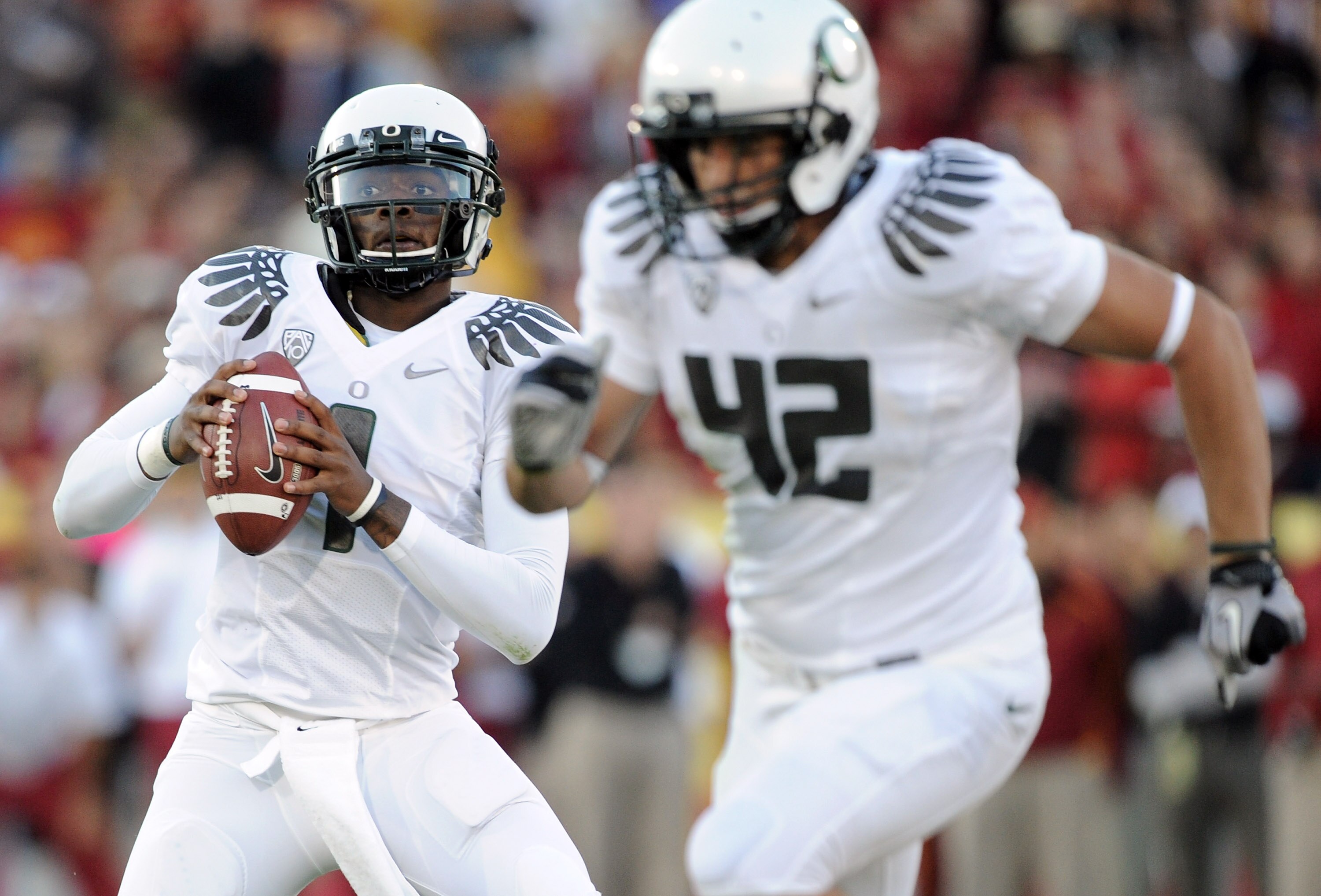 LOS ANGELES, CA - OCTOBER 30:  Darron Thomas #1 of the Oregon Ducks rolls out of the pocket behind David Paulson #42 against the USC Trojans during the game at Los Angeles Memorial Coliseum on October 30, 2010 in Los Angeles, California.  (Photo by Harry