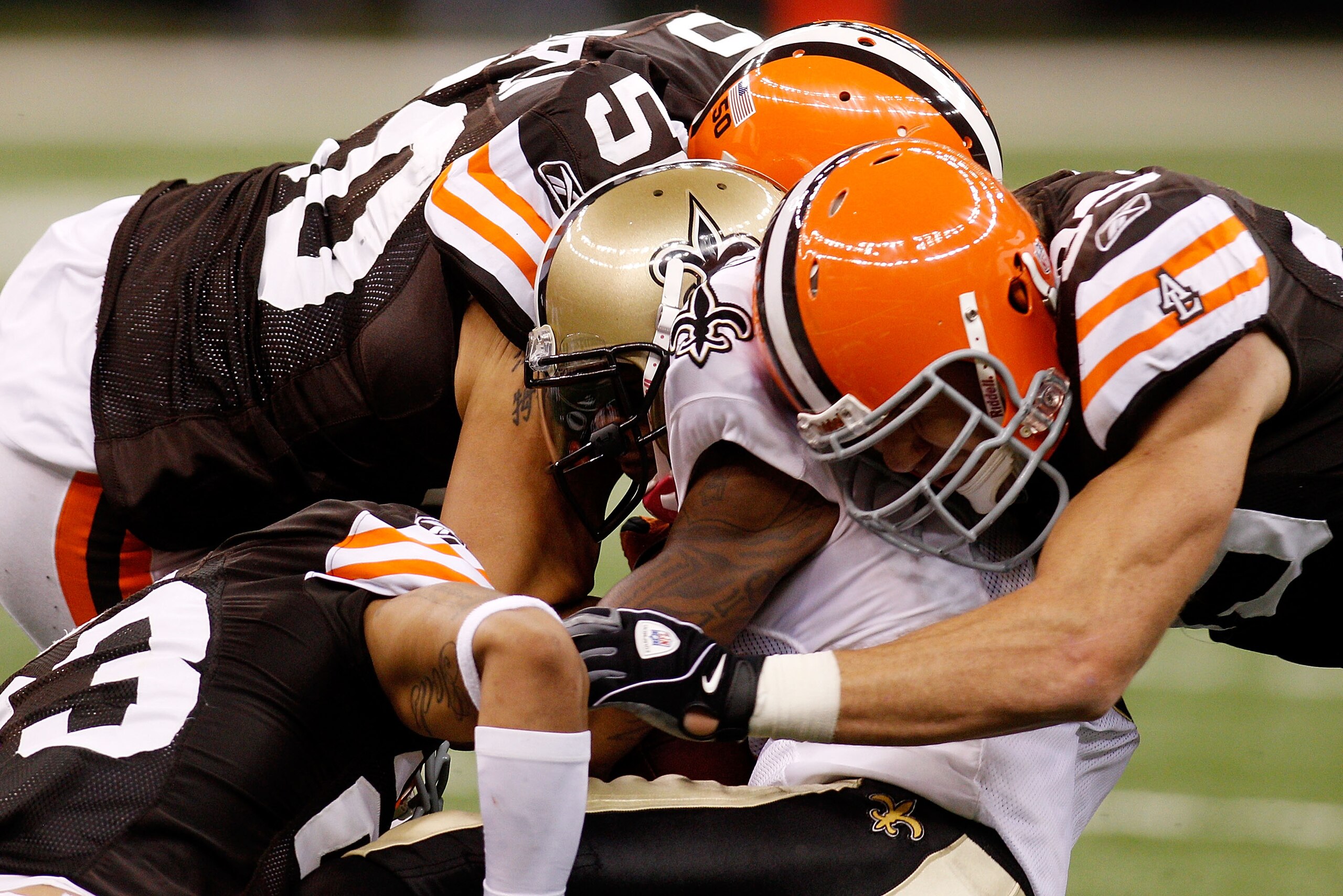 NEW ORLEANS - OCTOBER 24:  Marques Colston #12 of the New Orleans Saints is tackled by Joe Haden #23, Scott Fujita #99 and Eric Barton #50 of the Cleveland Browns at the Louisiana Superdome on October 24, 2010 in New Orleans, Louisiana.  The Browns defeat
