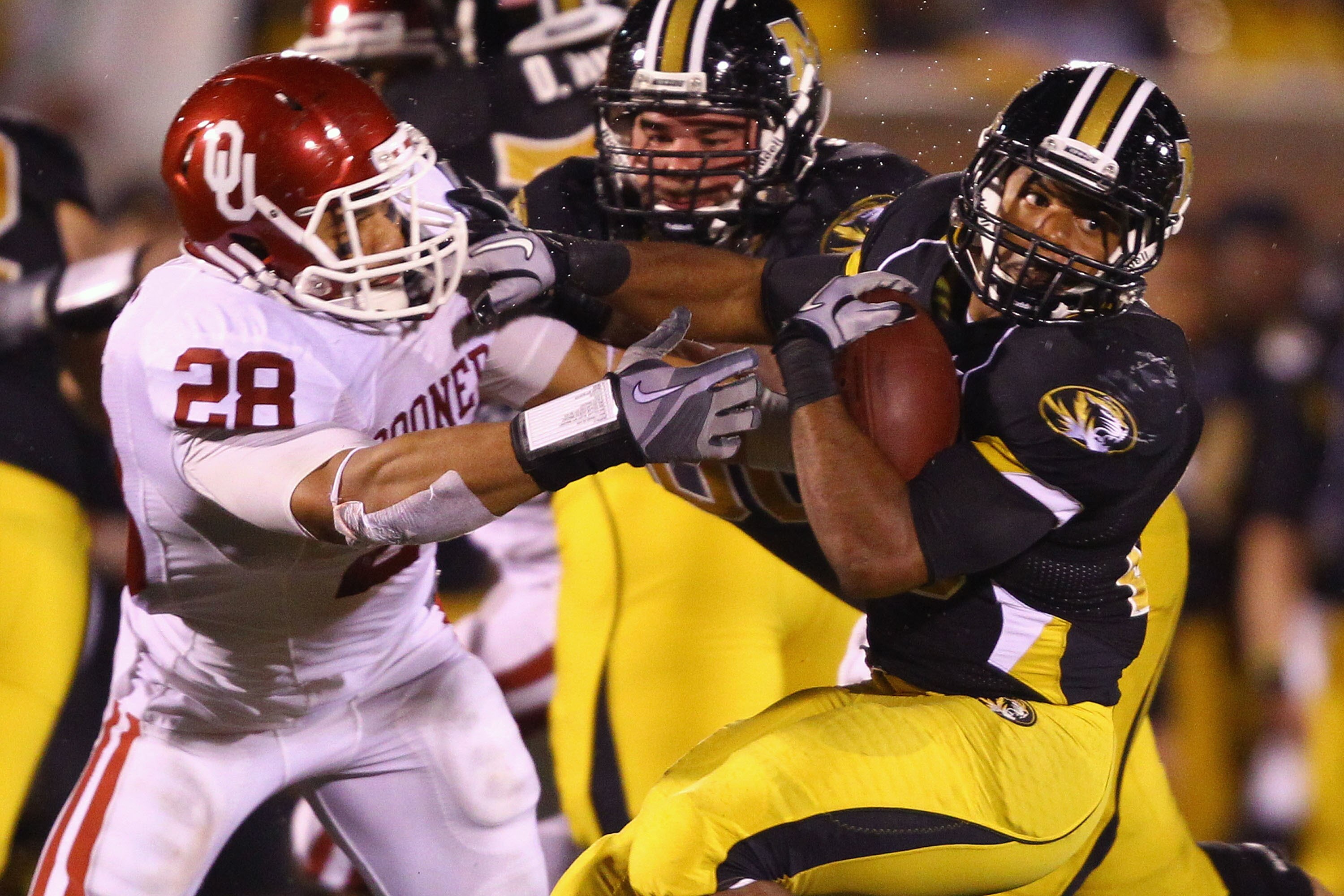 COLUMBIA, MISSOURI - OCTOBER 23: De'Vion Moore #26 of the Missouri Tigers looks to get past Travis Lewis #28 of the Oklahoma Sooners at Faurot Field/Memorial Stadium on October 23, 2010 in Columbia, Missouri.  The Tigers beat the Sooners 36-27.  (Photo by