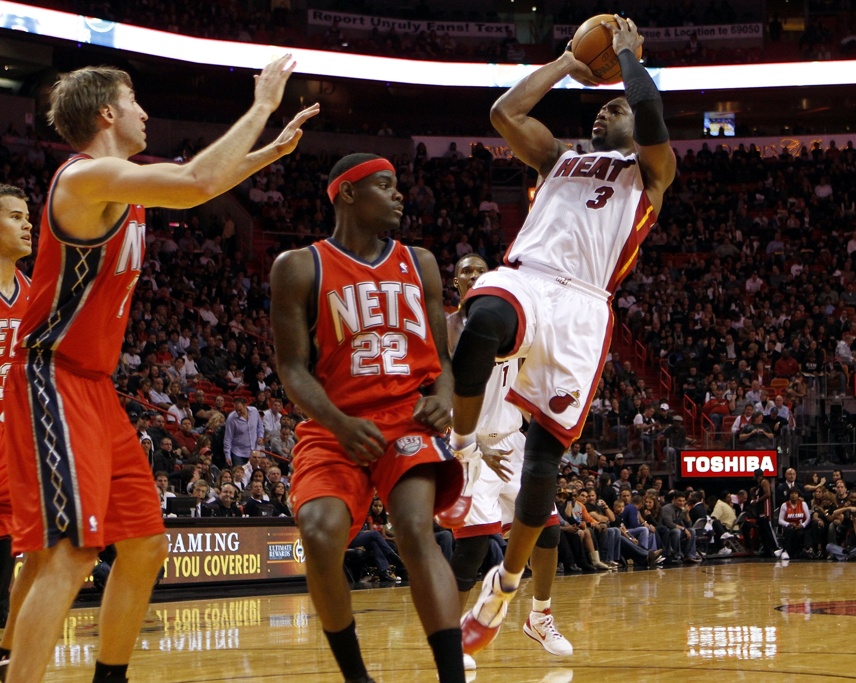 MIAMI - NOVEMBER 06:  Guard Dwyane Wade #3 of the Miami Heat passes against gueard Anthony Morrow #22 of the New Jersey Nets  at American Airlines Arena on November 6, 2010 in Miami, Florida. NOTE TO USER: User expressly acknowledges and agrees that, by d