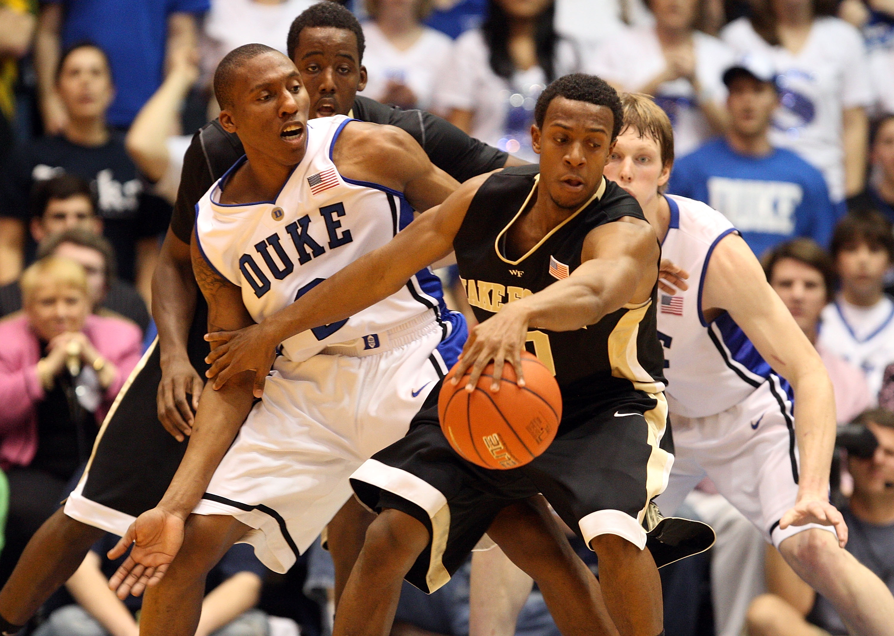 DURHAM, NC - JANUARY 17:  Ishmael Smith #10 and teammate Al-Farouq Aminu #1 of the Wake Forest Demon Deacons keep the ball away from Nolan Smith #2 and Kyle Singler #12 of the Duke Blue Devils during their game on January 17, 2010 in Durham, North Carolin