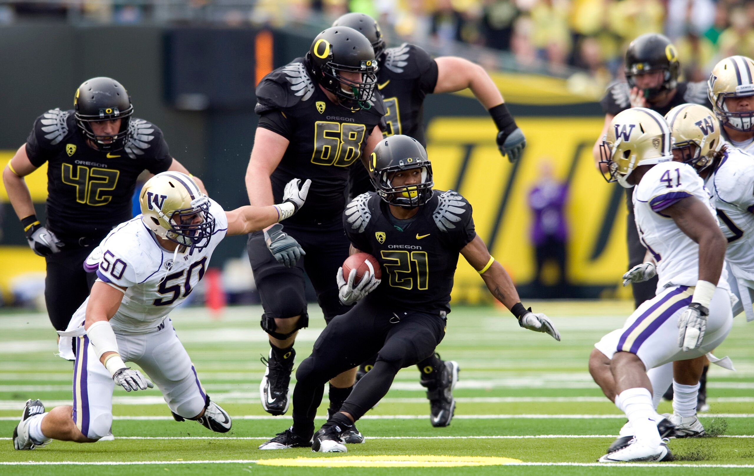 EUGENE, OR - NOVEMBER 6: Running back LaMichael James #21 of the Oregon Ducks looks for some running room as he is surrounded by defensive end Kalani Aldrich #50 and linebacker Victor Aiyewa #41 of the Washington Huskies in the second quarter of the game