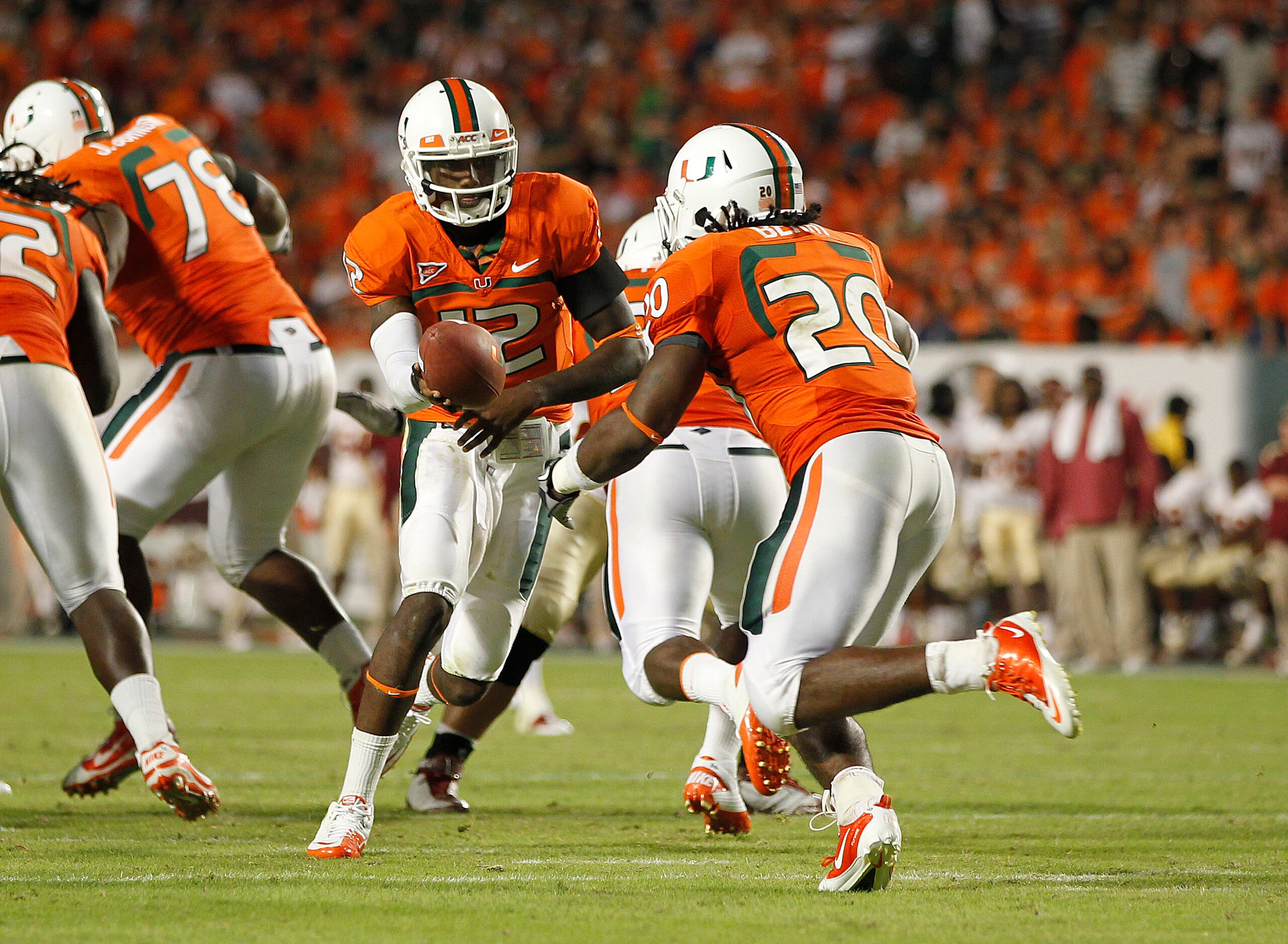MIAMI, FL - OCTOBER 9: Jacory Harris #12 hands the ball off to Damien Berry #20 of the Miami Hurricanes against the Florida State Seminoles on October 9, 2010 at Sun Life Stadium in Miami, Florida. The Seminoles defeated the Hurricanes 45-17. (Photo by Jo MIAMI, FL - OCTOBER 9: Jacory Harris #12 hands the ball off to Damien Berry #20 of the Miami Hurricanes against the Florida State Seminoles on October 9, 2010 at Sun Life Stadium in Miami, Florida. The Seminoles defeated the Hurricanes 45-17. (Photo by Jo