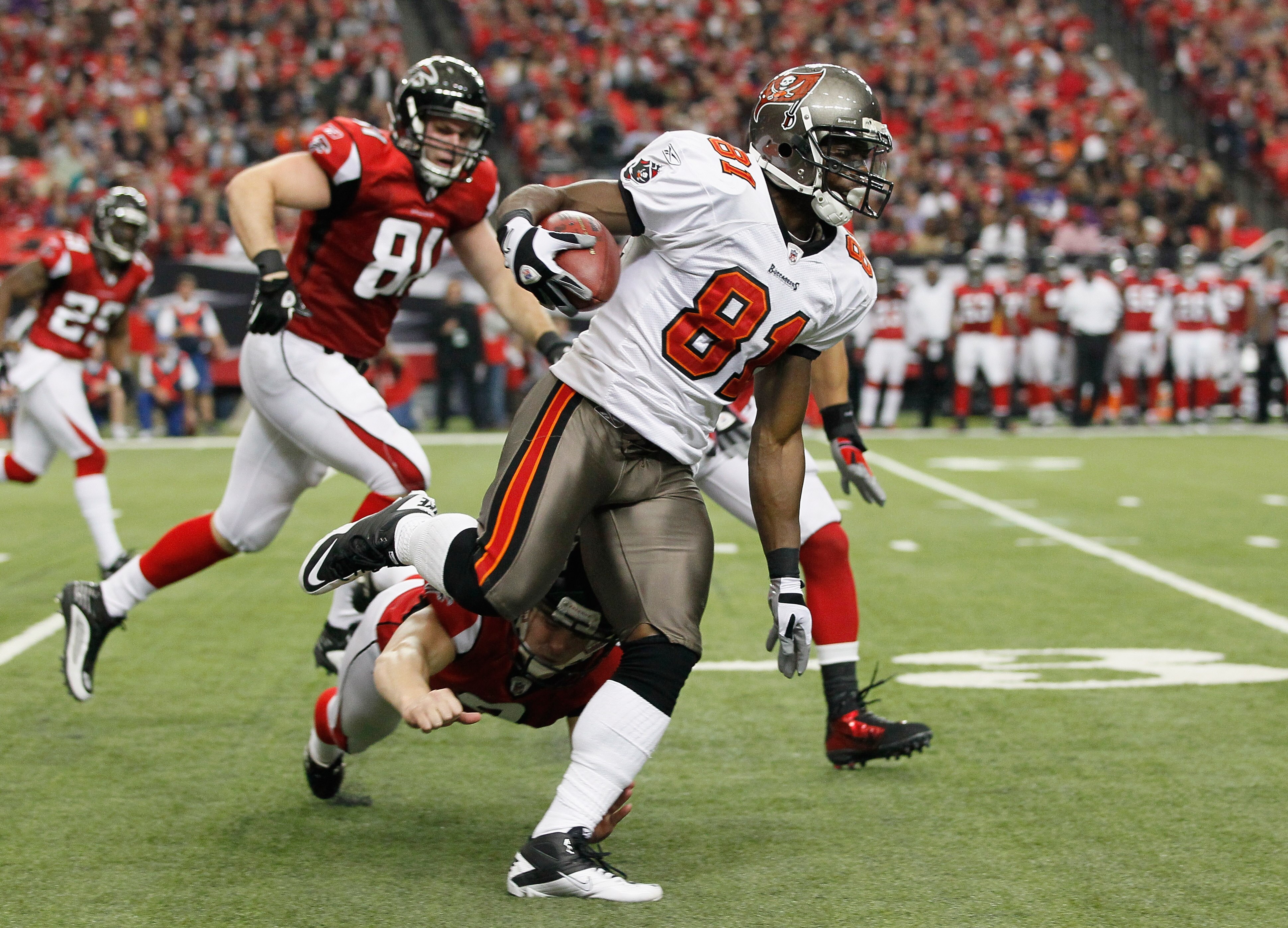 ATLANTA - NOVEMBER 07:  Micheal Spurlock #81 of the Tampa Bay Buccaneers returns a punt and avoids a tackle by Michael Koenen #9 of the Atlanta Falcons for a touchdown at Georgia Dome on November 7, 2010 in Atlanta, Georgia.  (Photo by Kevin C. Cox/Getty