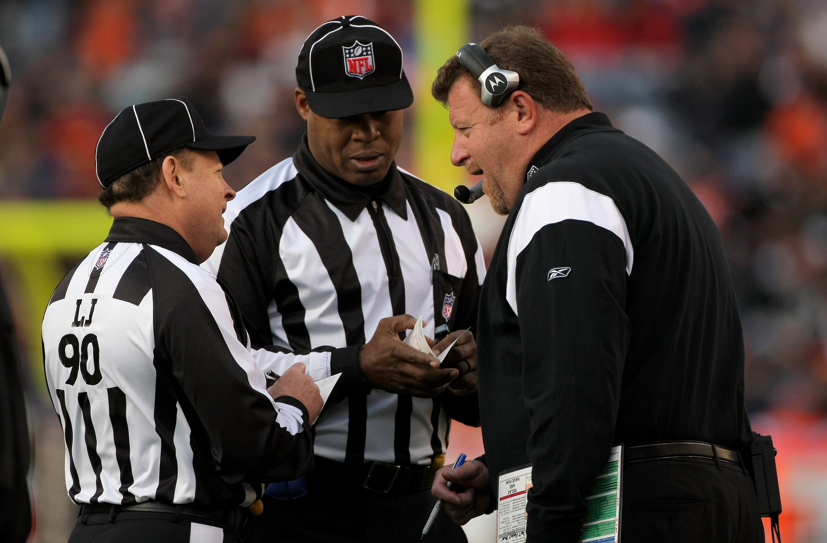 DENVER - NOVEMBER 23:  Head coach Tom Cable of the Oakland Raiders talks with line jidge Mike Spanier (L) and field judge Boris Cheek (C) as the Raiders face the Denver Broncos during week 12 NFL action at Invesco Field at Mile High on November 23, 2008 i
