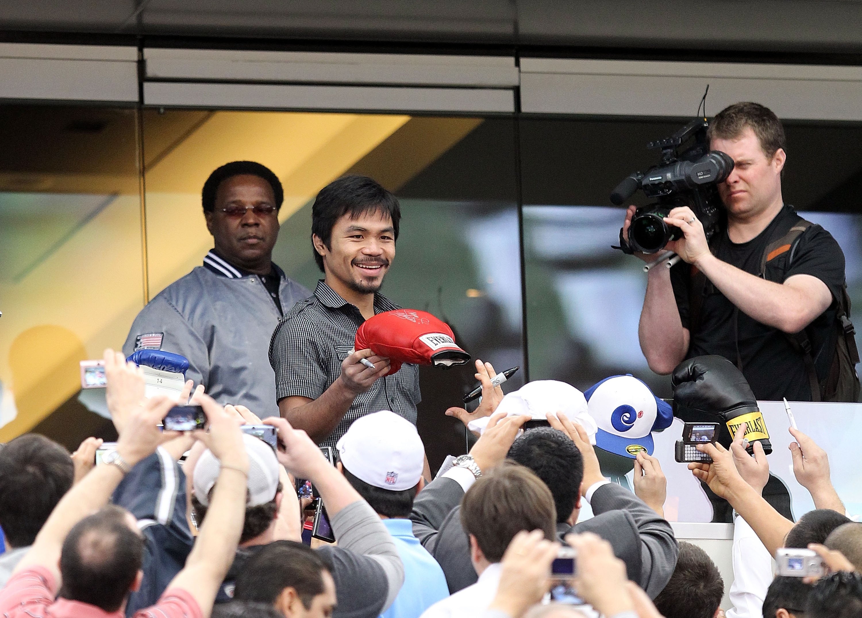 ARLINGTON, TX - JANUARY 19:  Manny Pacquiao signs autographs before a press conference at Cowboys Stadium on January 19, 2010 in Arlington, Texas.  (Photo by Ronald Martinez/Getty Images)