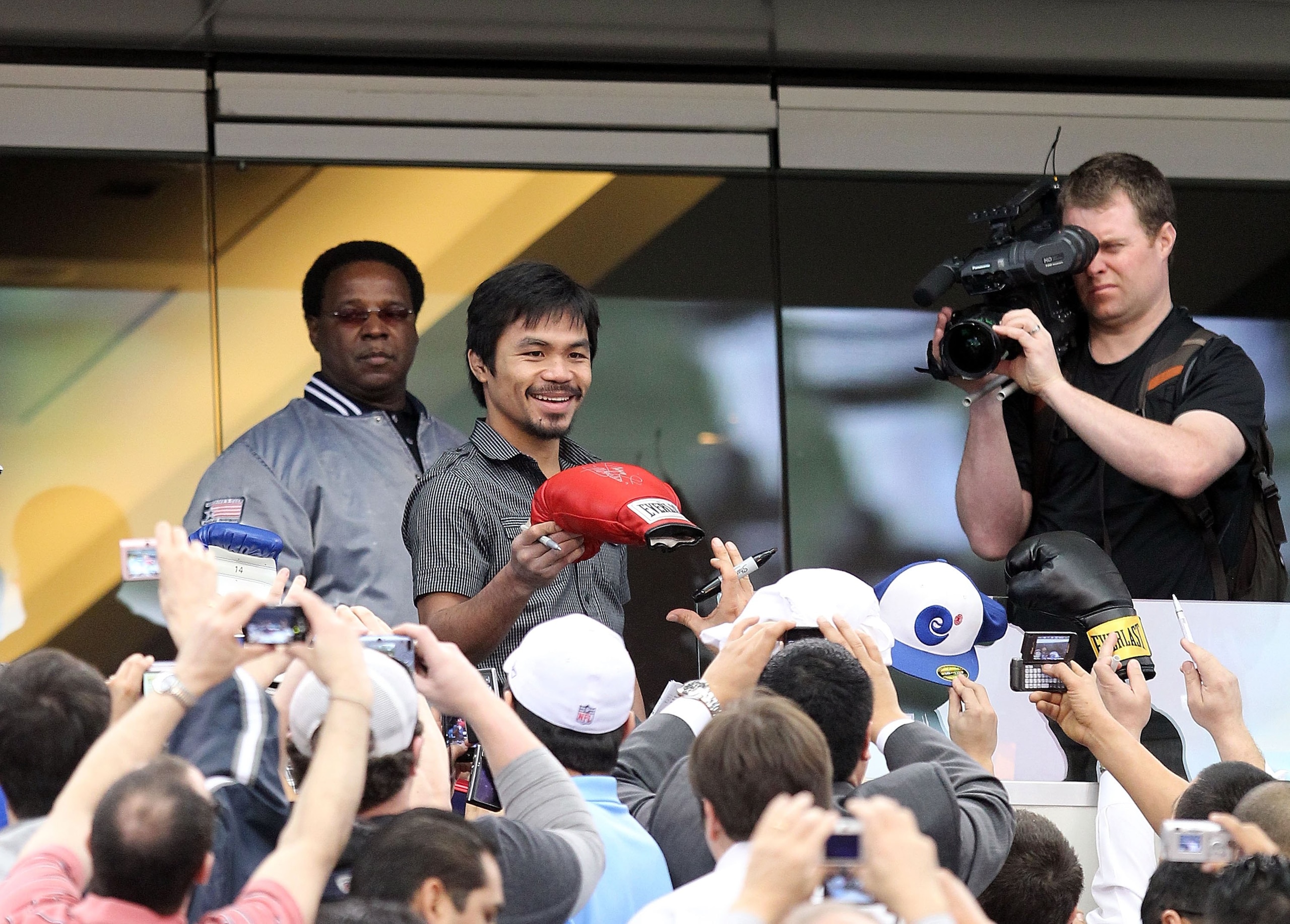 ARLINGTON, TX - JANUARY 19:  Manny Pacquiao signs autographs before a press conference at Cowboys Stadium on January 19, 2010 in Arlington, Texas.  (Photo by Ronald Martinez/Getty Images)