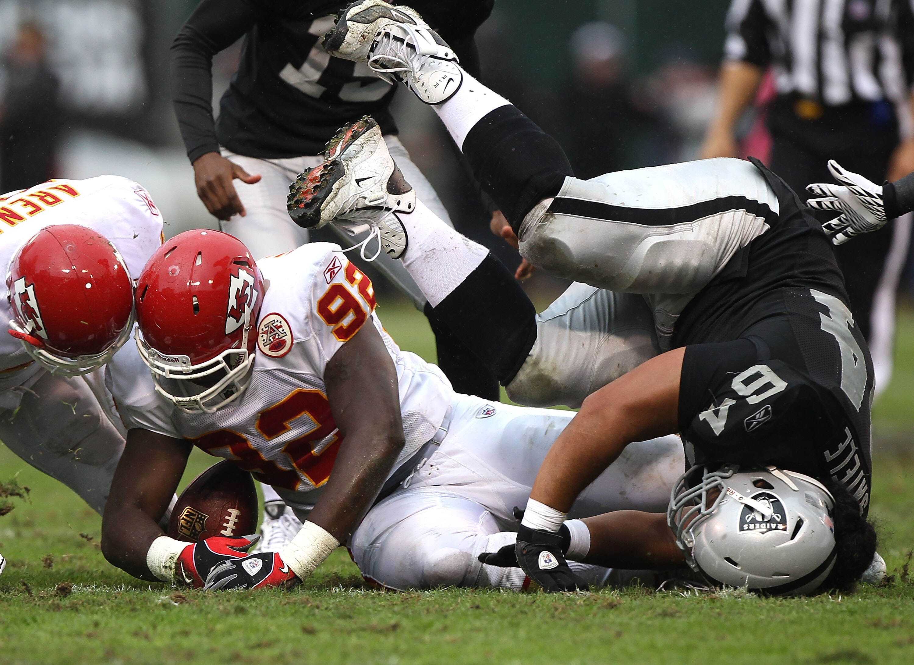 OAKLAND, CA - NOVEMBER 7:  Wallace Gilberry #92 of the Kansas City Chiefs recovers a fumble over Samson Satele #64 of the Oakland Raiders during an NFL game at Oakland-Alameda County Coliseum on November 7, 2010 in Oakland, California.  (Photo by Jed Jaco