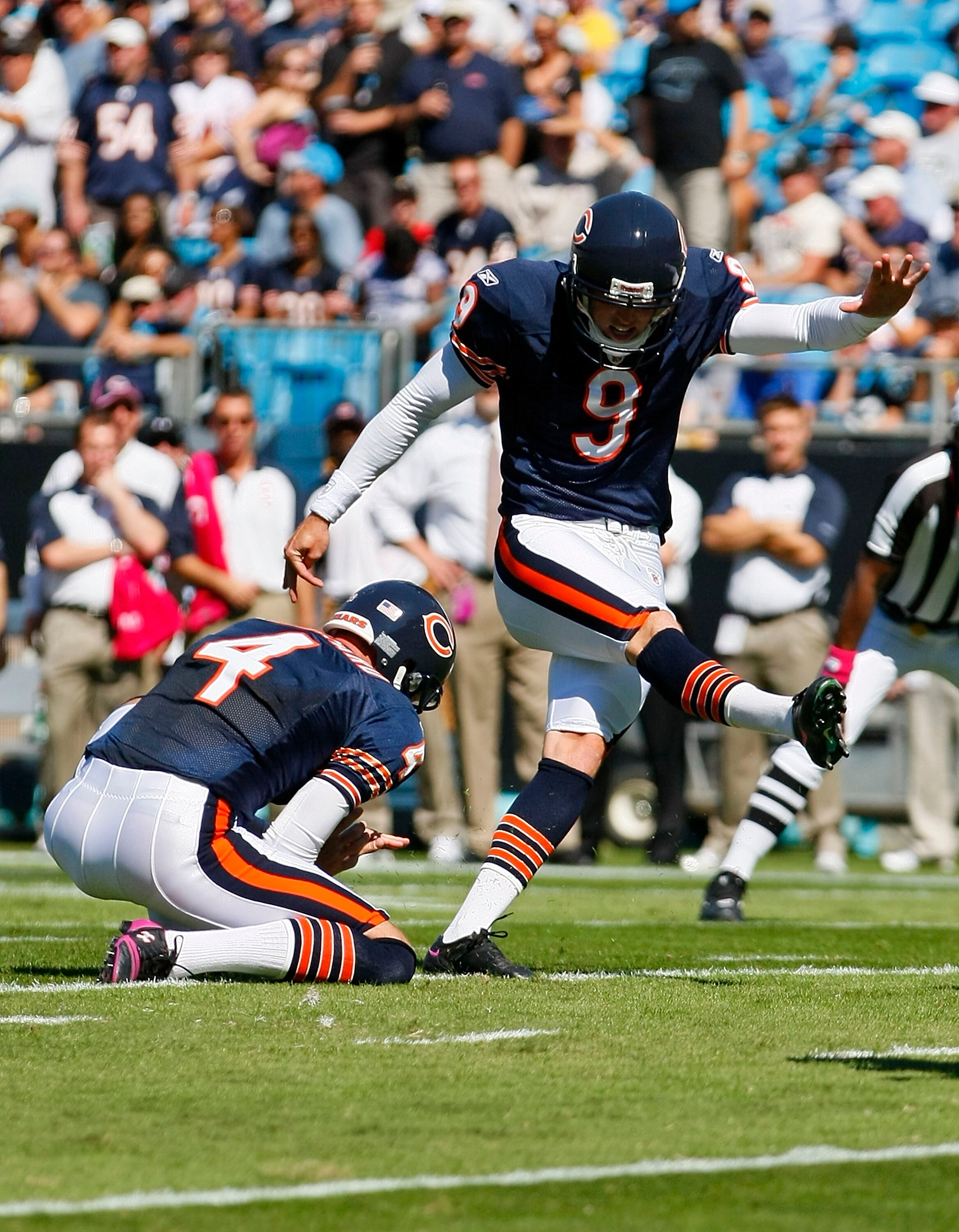 CHARLOTTE, NC - OCTOBER 10: Place kicker Robbie Gould #9 of the Chicago Bears kicks a field goal out of the hold of punter Brad Maynard #4 of the Chicago Bears against the Carolina Panthers at Bank of America Stadium on October 10, 2010 in Charlotte, Nort