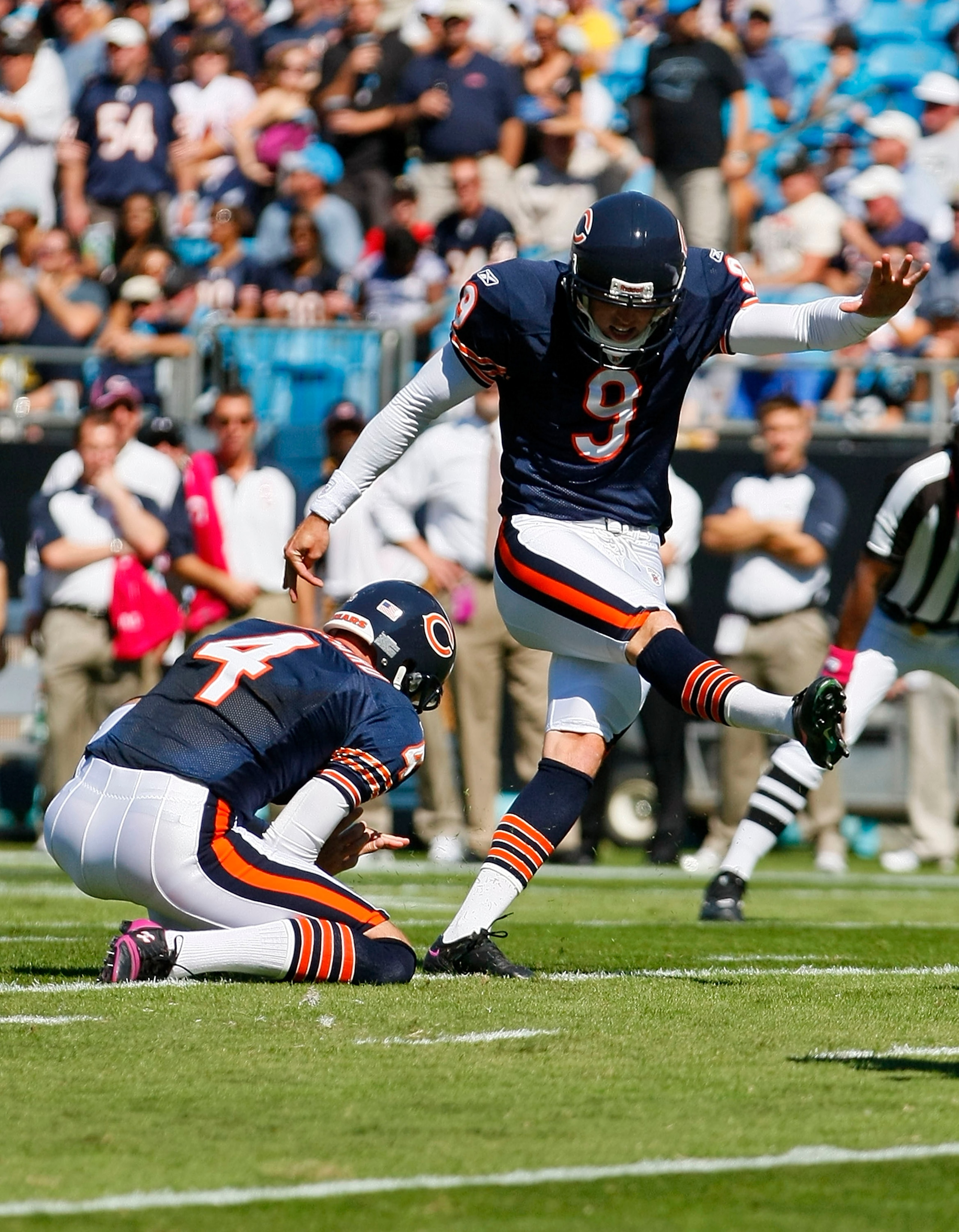 CHARLOTTE, NC - OCTOBER 10: Place kicker Robbie Gould #9 of the Chicago Bears kicks a field goal out of the hold of punter Brad Maynard #4 of the Chicago Bears against the Carolina Panthers at Bank of America Stadium on October 10, 2010 in Charlotte, Nort