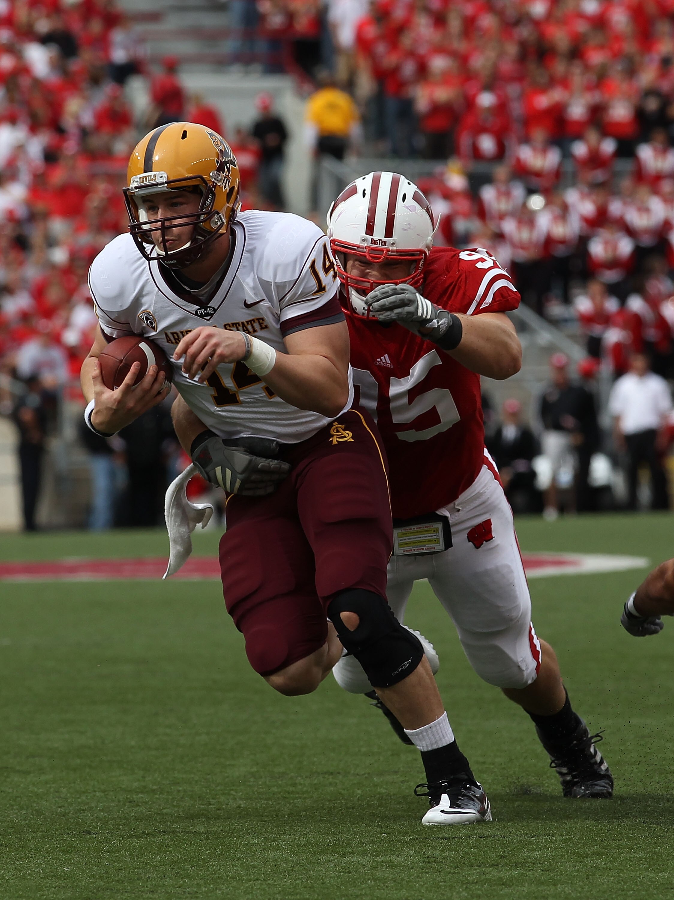 MADISON, WI - SEPTEMBER 18: Steven Threet #14 of the Arizona State Sun Devils tries to break away from Patrick Butrym #95 of the Wisconsin Badgers at Camp Randall Stadium on September 18, 2010 in Madison, Wisconsin. Wisconsin defeated Arizona State 20-19.