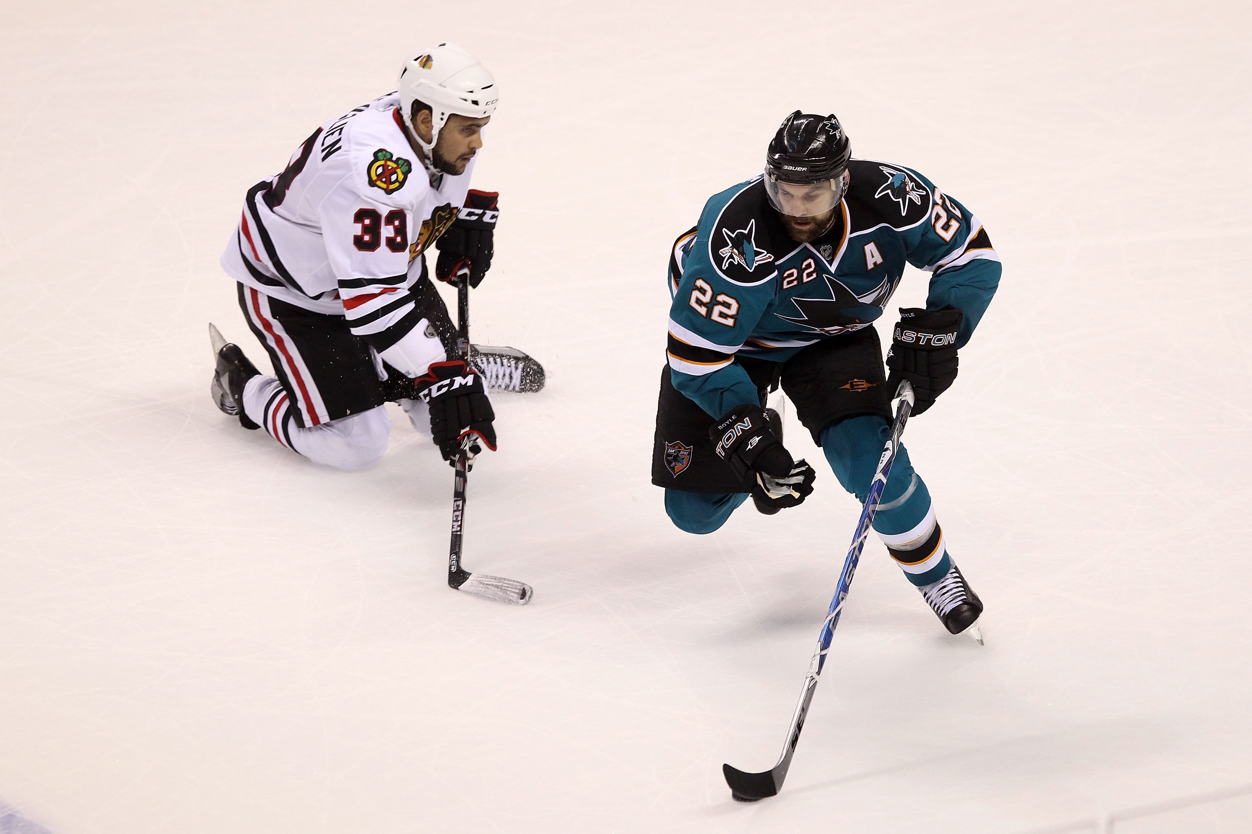 SAN JOSE, CA - MAY 18:  Dan Boyle #22 of the San Jose Sharks moves the puck next to Dustin Byfuglien #33 of the Chicago Blackhawks in Game Two of the Western Conference Finals during the 2010 NHL Stanley Cup Playoffs at HP Pavilion on May 18, 2010 in San
