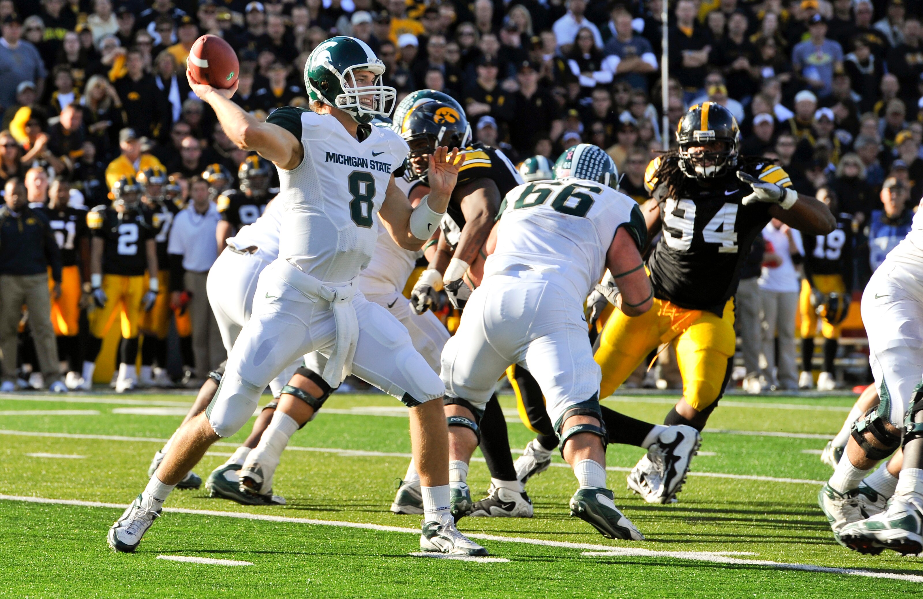 IOWA CITY, IA - OCTOBER 30- Quarterback Kirk Cousins #8 of the Michigan State Spartans throws under pressure from Defensive lineman Adrian Clayborn #94 of the University of Iowa Hawkeyes during the first half of play at Kinnick Stadium on October 30, 2010