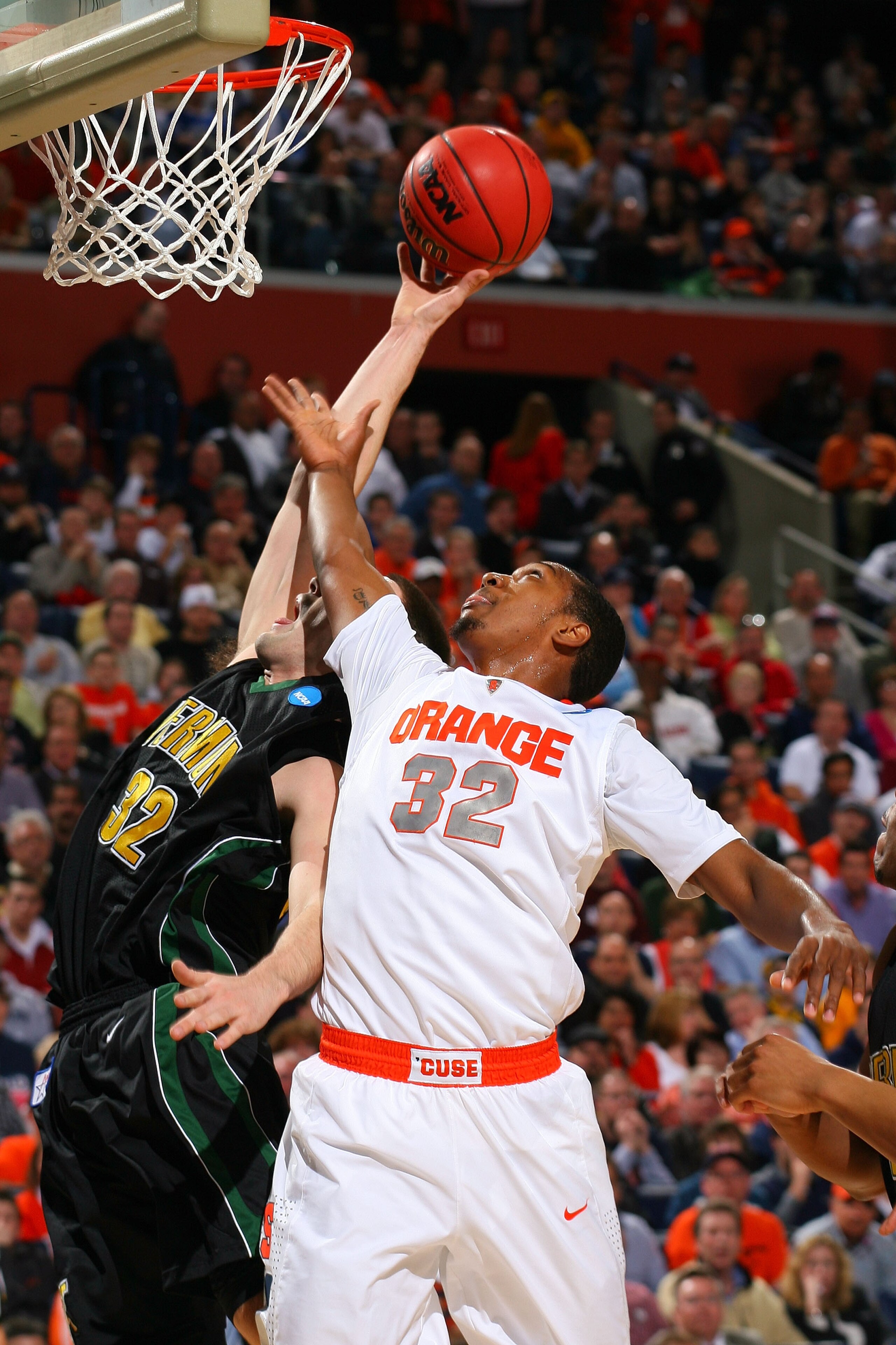 BUFFALO, NY - MARCH 19:  Evan Fjeld #32 of the Vermont Catamounts goes to the hoop against Kris Joseph #32 of the Syracuse Orange during the first round of the 2010 NCAA men's basketball tournament at HSBC Arena on March 19, 2010 in Buffalo, New York.  (P