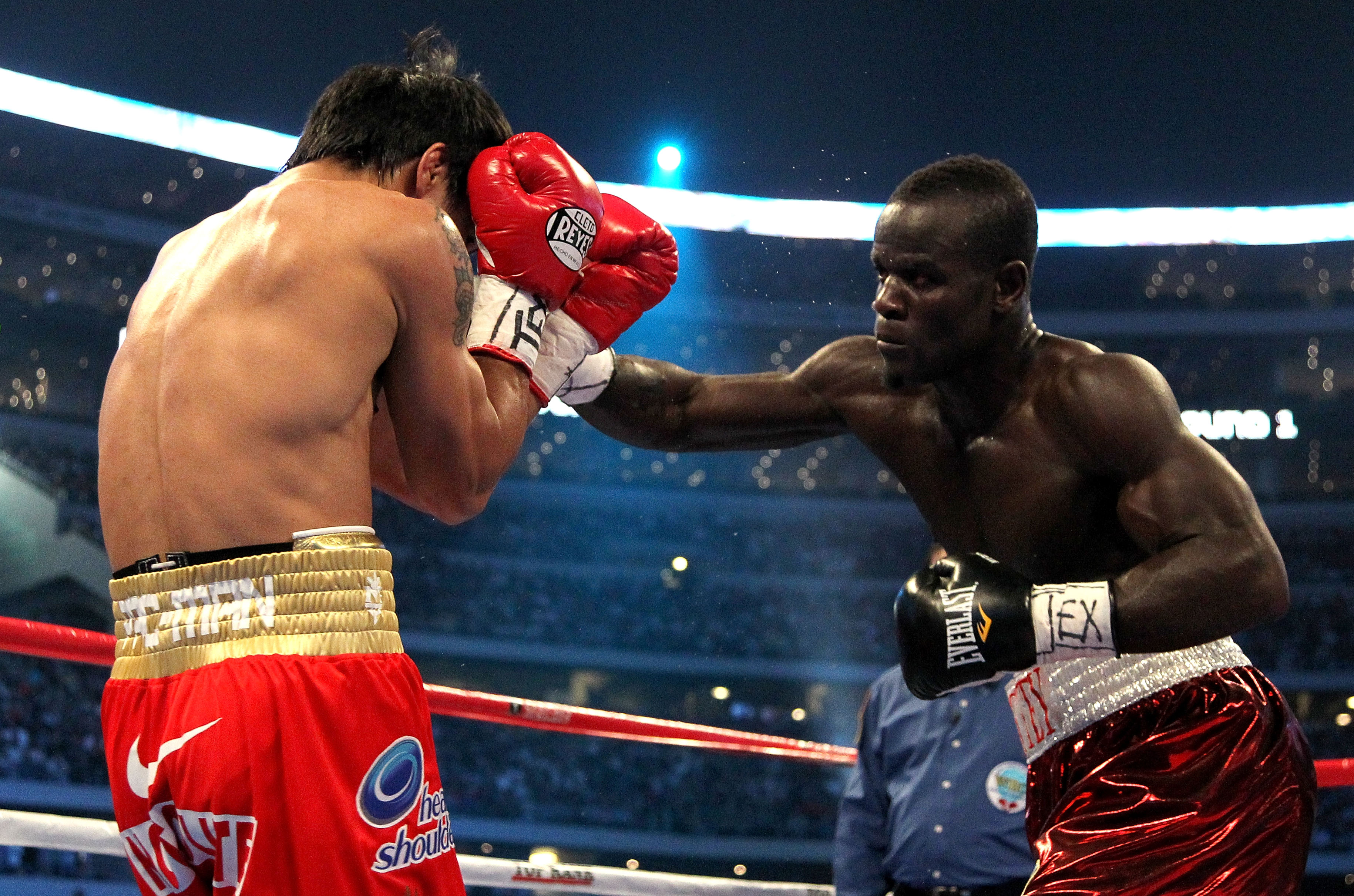 ARLINGTON, TX - MARCH 13:  (R-L) Joshua Clottey of Ghana throws a right to the face of Manny Pacquiao of the Philippines during the WBO welterweight title fight at Cowboys Stadium on March 13, 2010 in Arlington, Texas.  (Photo by Jed Jacobsohn/Getty Image