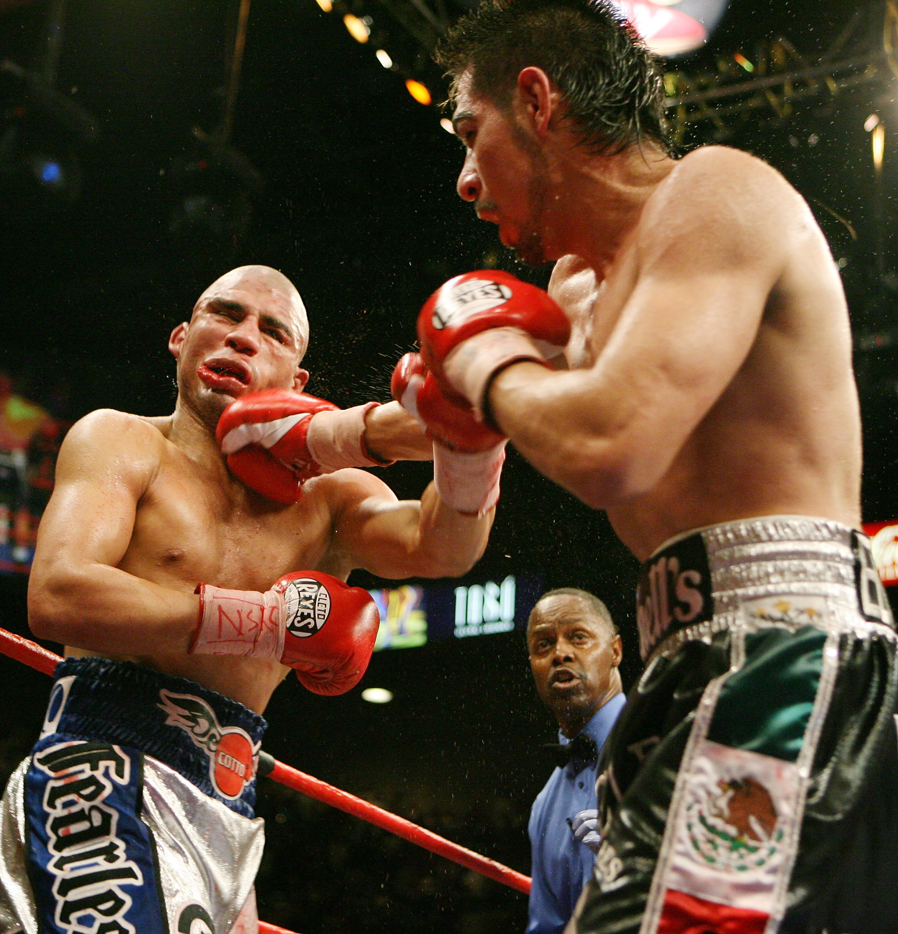 LAS VEGAS - JULY 26:  Antonio Margarito (R) hits Miguel Cotto as referee Kenny Bayless (C) looks on during their WBA welterweight title fight at the MGM Grand Garden Arena July 26, 2008 in Las Vegas, Nevada. Margarito won by TKO in the 11th round.  (Photo