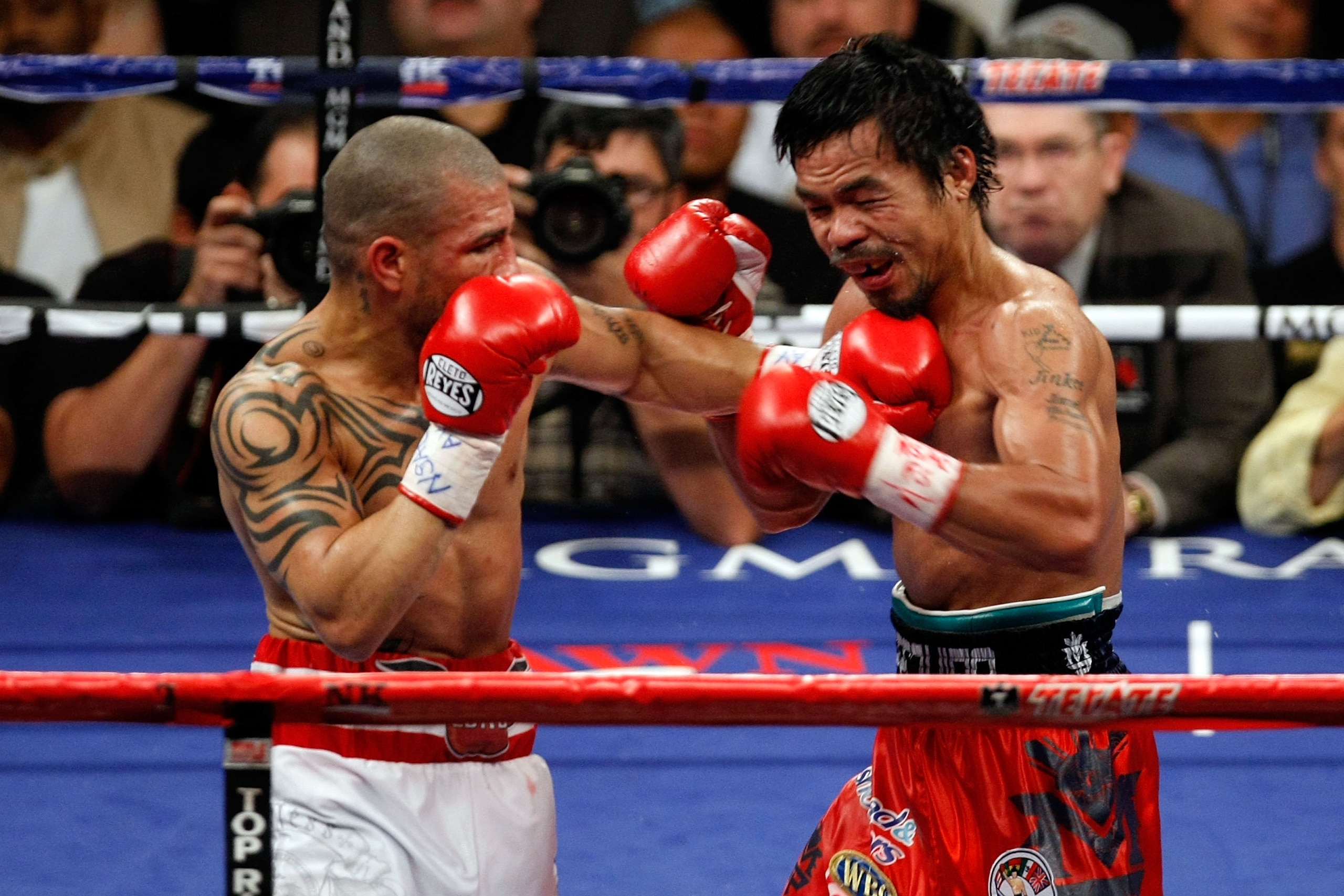 LAS VEGAS - NOVEMBER 14:  (L-R) Miguel Cotto of Puerto Rico throws a left to the body of Manny Pacquiao during their WBO welterweight title fight at the MGM Grand Garden Arena on November 14, 2009 in Las Vegas, Nevada. Pacquiao defeated Cotto by 12th roun