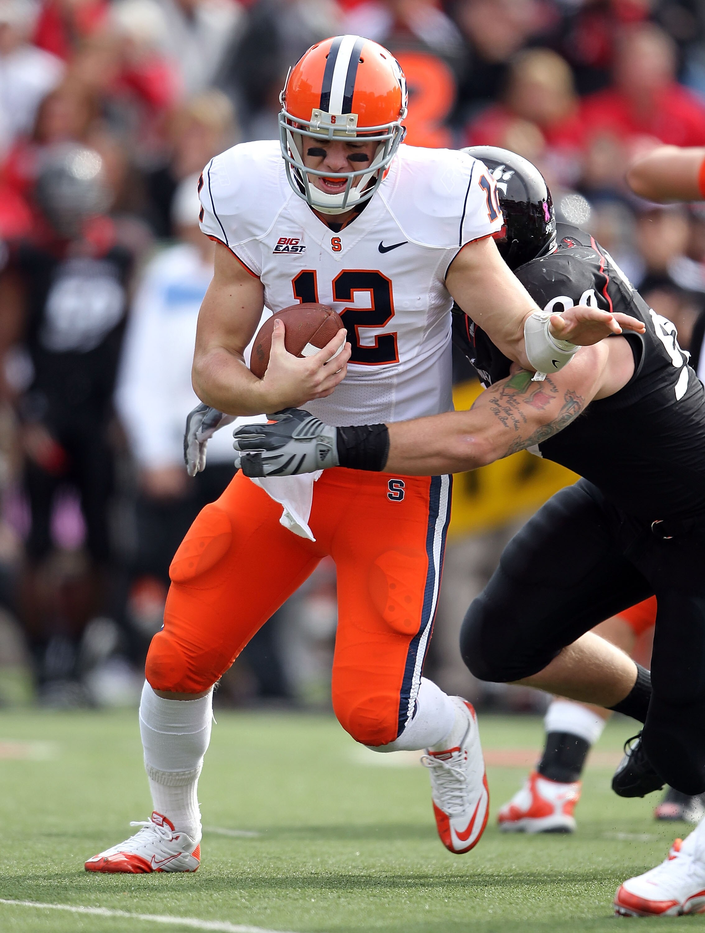 CINCINNATI - OCTOBER 30:  Ryan Nassib #12 of the Syracuse Orange is sacked by Dan Giordano #99 of the Cincinnati Bearcats during the Big East Conference game at Nippert Stadium on October 30, 2010 in Cincinnati, Ohio.  (Photo by Andy Lyons/Getty Images)