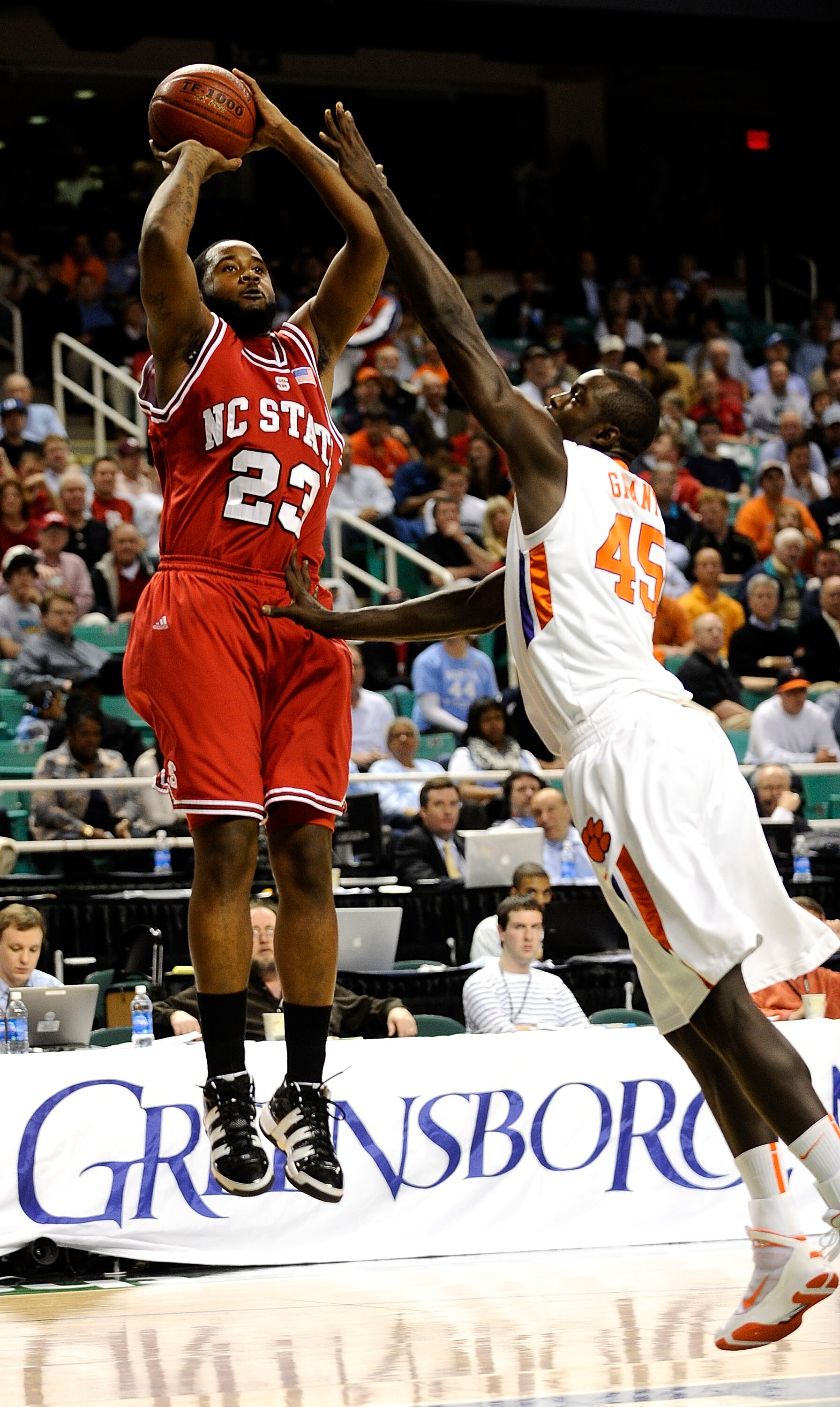 GREENSBORO, NC - MARCH 11:  Jerai Grant #45 of the Clemson Tigers guards Tracy Smith #23 of the North Carolina State Wolfpack in their first-round game in the 2010 ACC Men's Basketball Tournament at the Greensboro Coliseum on March 11, 2010 in Greensboro,