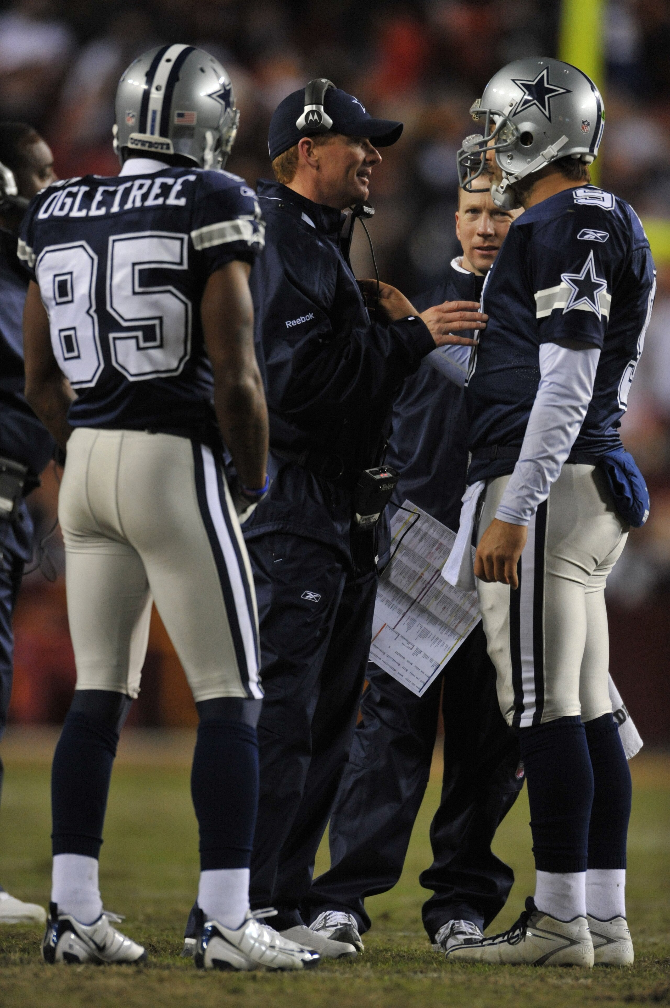 LANDOVER, MD - DECEMBER 27:  Assistant head coach Jason Garrett of the Dallas Cowboys speaks with Tony Romo #9 during the game against the Washington Redskins at FedExField on December 27, 2009 in Landover, Maryland. The Cowboys defeated the Redskins 17-0