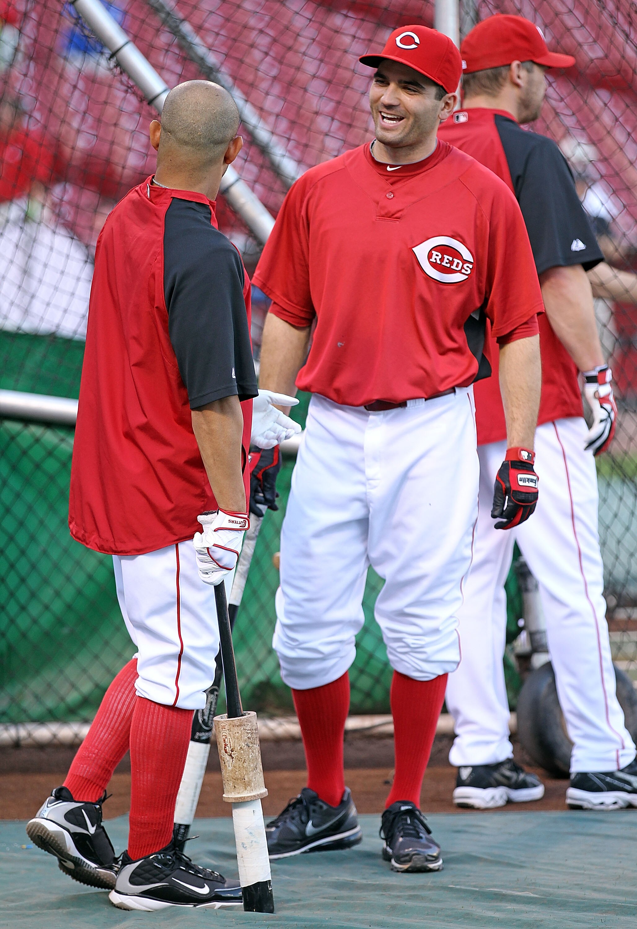 CINCINNATI - OCTOBER 10:  Joey Votto #19 (right) of the Cincinnati Reds shares a laugh with Orlando Cabrera #2 in batting practice before the start of  Game 3 of the NLDS against the Philadelphia Phillies  at Great American Ball Park on October 10, 2010 i
