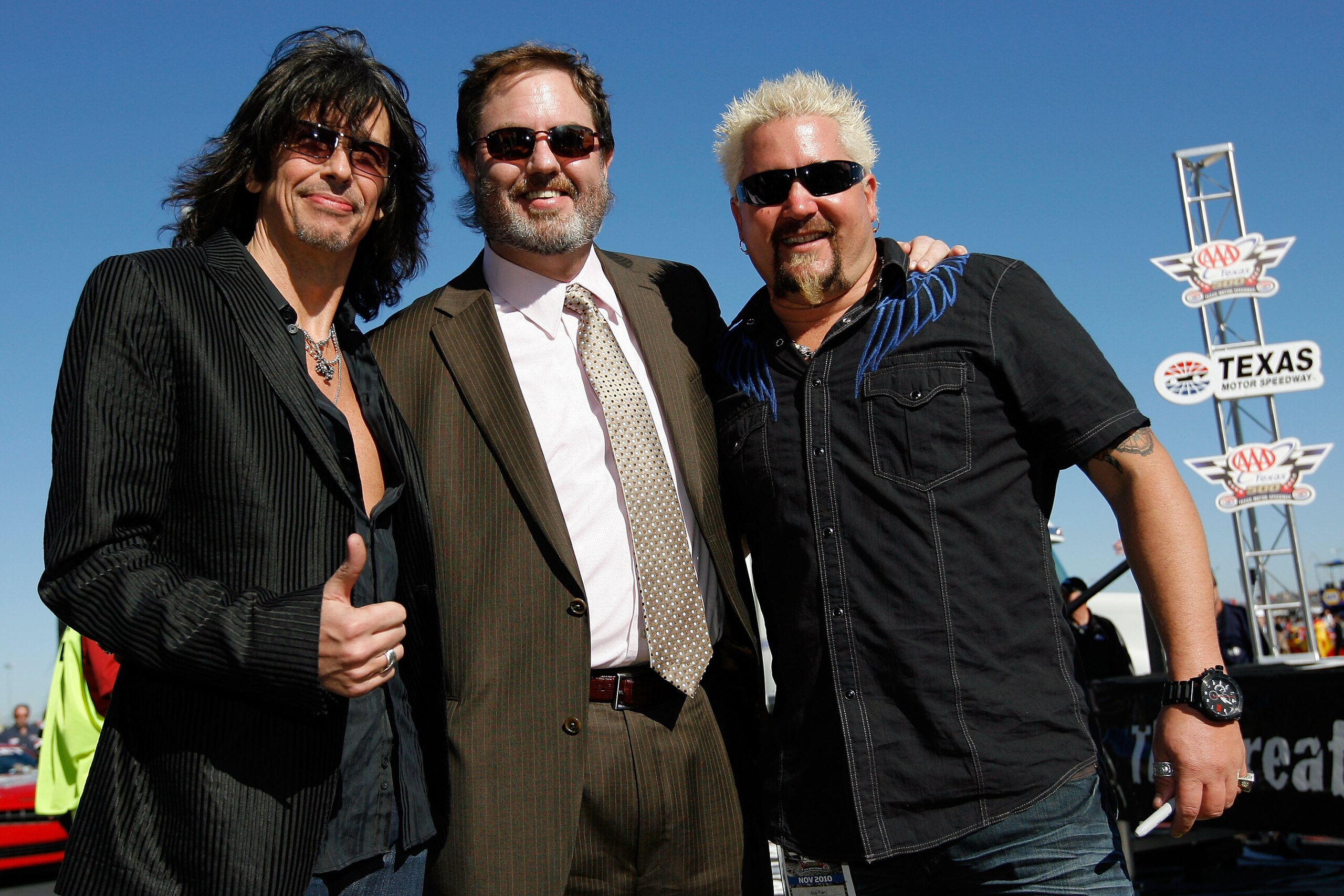 FORT WORTH, TX - NOVEMBER 07:  Lead singer of Foreigner Kelly Hansen, Texas Motor Speedway President Eddie Gossage and celebrity chef Guy Fieri pose during the NASCAR Sprint Cup Series AAA Texas 500 at Texas Motor Speedway on November 7, 2010 in Fort Wort