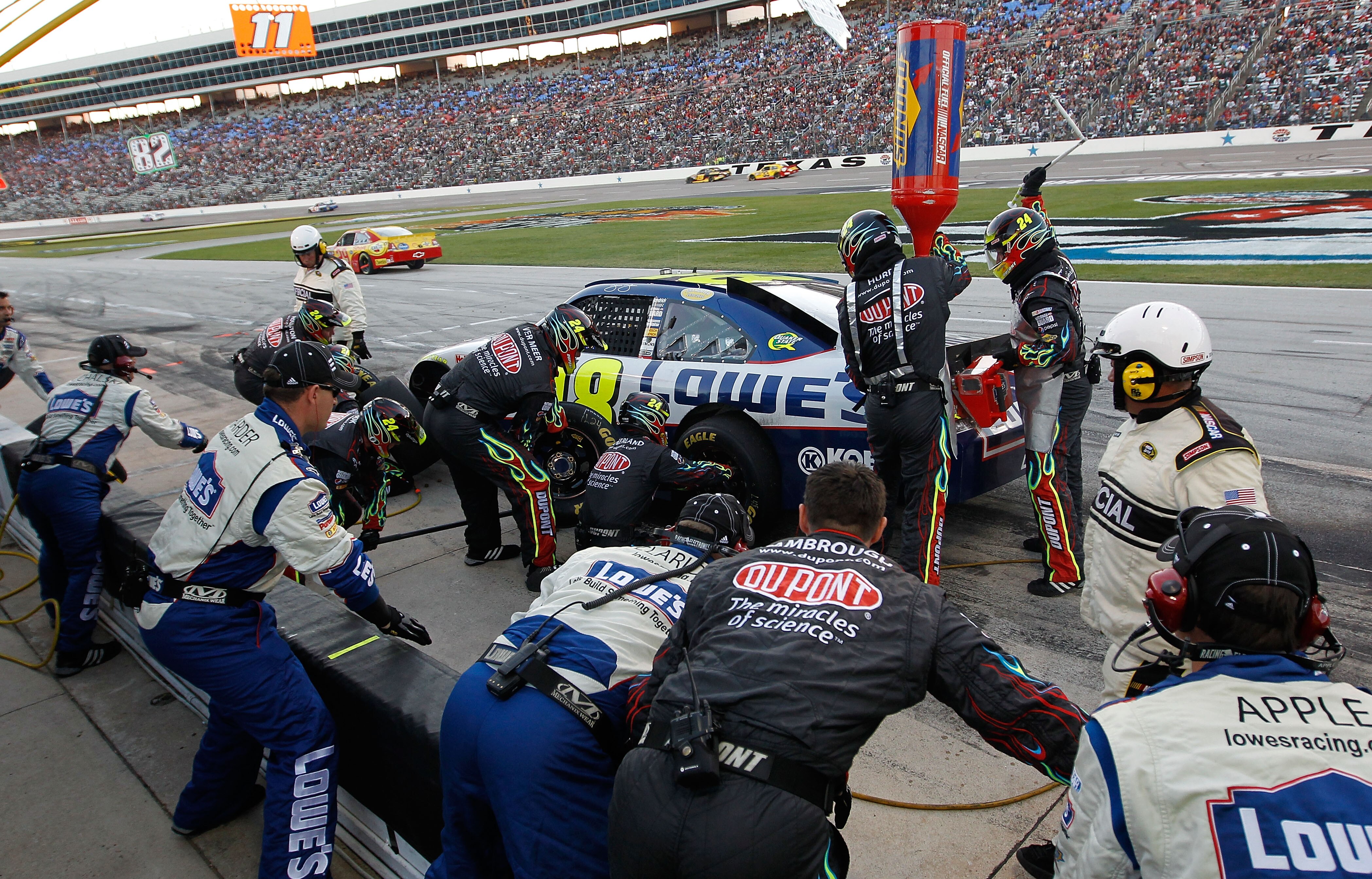 FORT WORTH, TX - NOVEMBER 07:  Crew members of the #24 DuPont/National Guard Chevrolet pit the #48 Lowe's Chevrolet, driven by Jimmie Johnson, during the NASCAR Sprint Cup Series AAA Texas 500 at Texas Motor Speedway on November 7, 2010 in Fort Worth, Tex