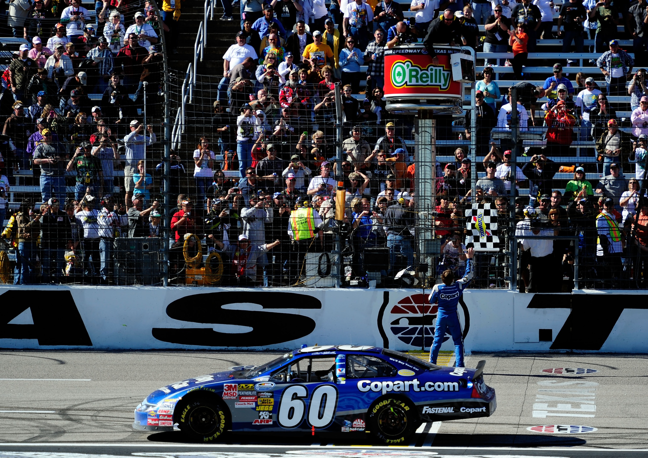FORT WORTH, TX - NOVEMBER 06:  Carl Edwards, driver of the #60 Copart.com Ford, catches the checkered flag after winning the NASCAR Nationwide Series O'Reilly Auto Parts Challenge at Texas Motor Speedway on November 6, 2010 in Fort Worth, Texas.  (Photo b