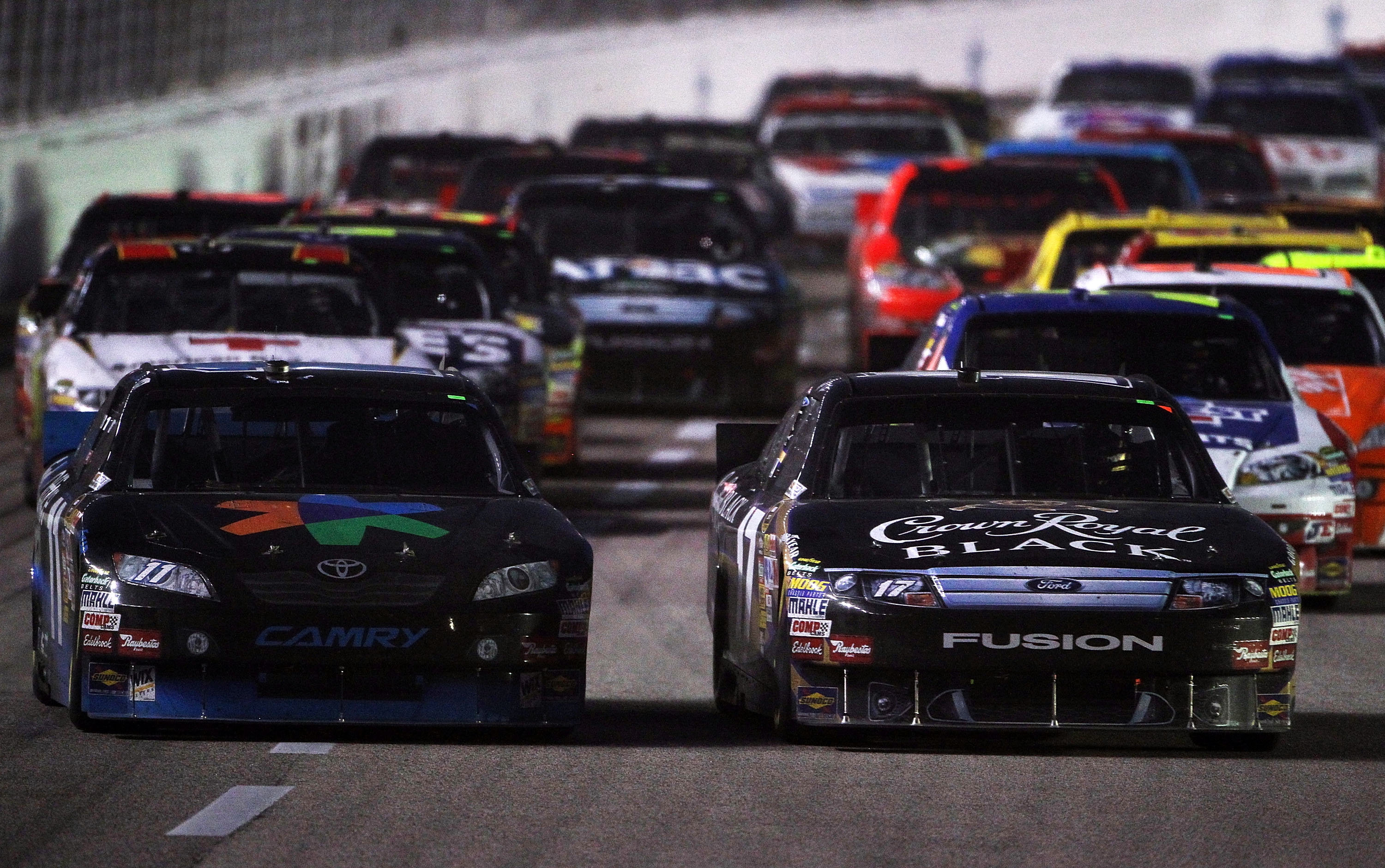 FORT WORTH, TX - NOVEMBER 07:  Denny Hamlin, driver of the #11 FedEx Office Toyota, and Matt Kenseth, driver of the #17 Crown Royal Black Ford, lead the field two wide during the NASCAR Sprint Cup Series AAA Texas 500 at Texas Motor Speedway on November 7