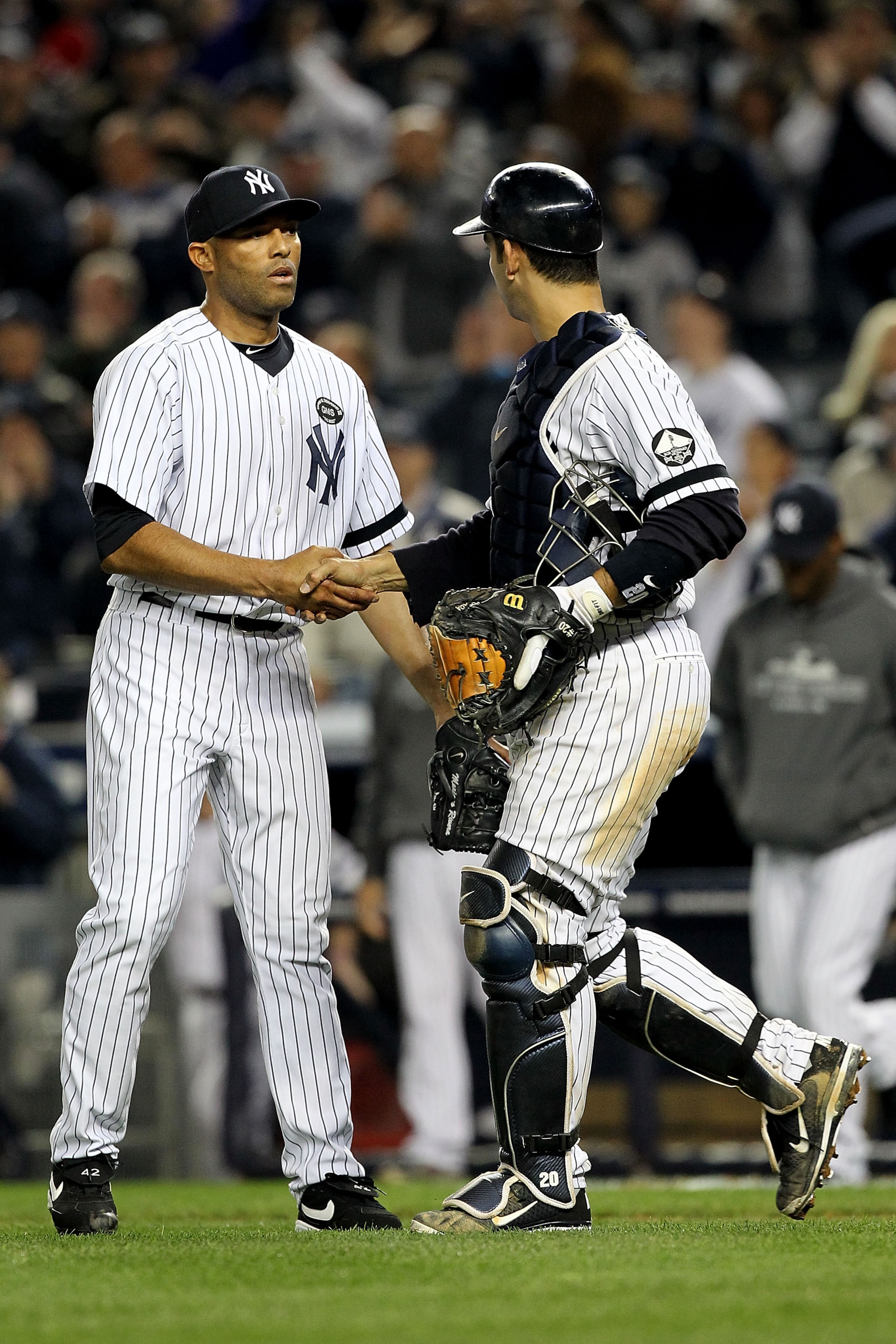 NEW YORK - OCTOBER 20:  Mariano Rivera #42 and Jorge Posada #20 of the New York Yankees celebrate after the Yankees won 7-2 against the Texas Rangers in Game Five of the ALCS during the 2010 MLB Playoffs at Yankee Stadium on October 20, 2010 in the Bronx