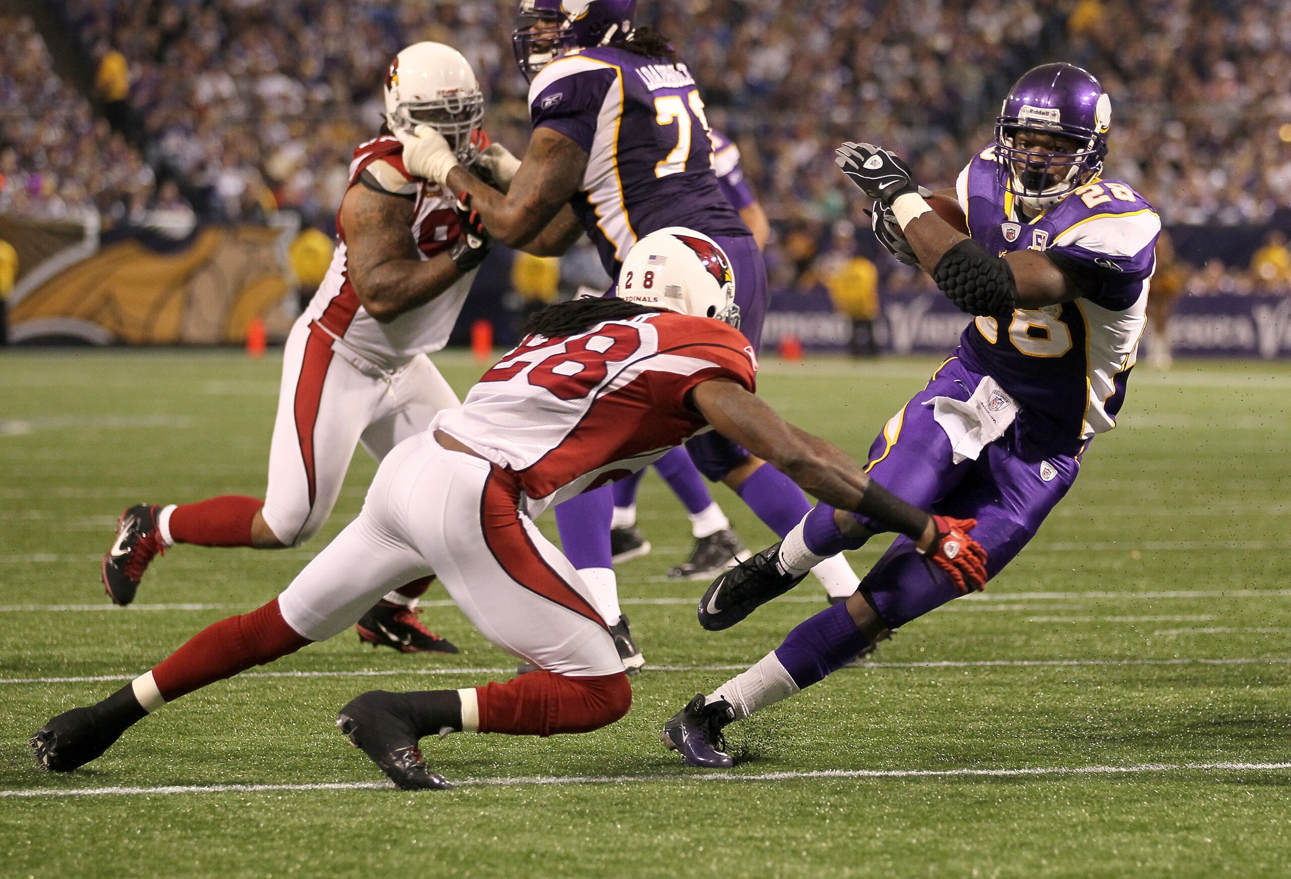 MINNEAPOLIS - NOVEMBER 07:  Running back Adrian Peterson #28 of the Minnesota Vikings carries the ball against cornerback Greg Toler #28 of the Arizona Cardinals in the fourth quarter at Hubert H. Humphrey Metrodome on November 7, 2010 in Minneapolis, Min