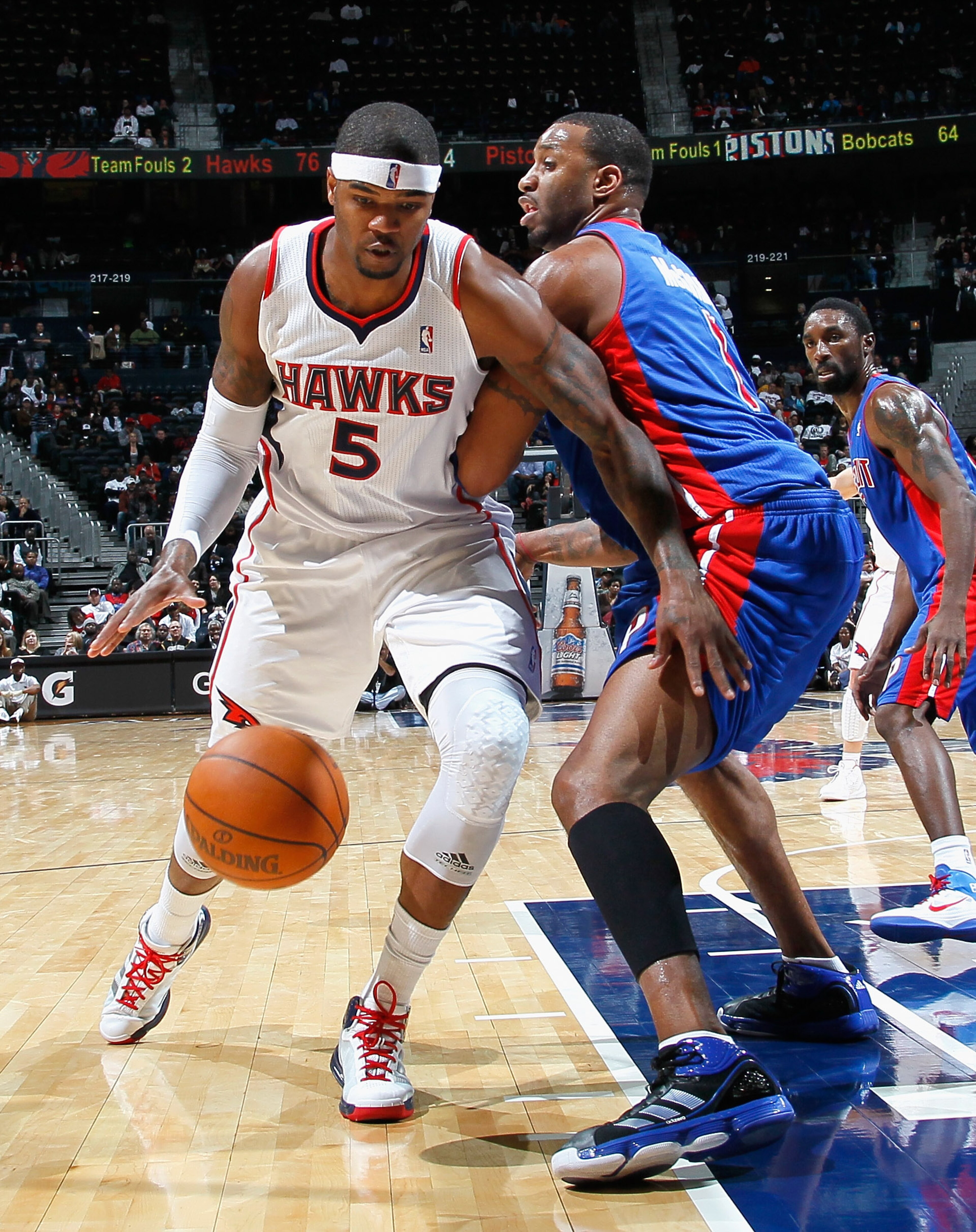 ATLANTA - NOVEMBER 03:  Josh Smith #5 of the Atlanta Hawks drives against Tracy McGrady #1 of the Detroit Pistons at Philips Arena on November 3, 2010 in Atlanta, Georgia.  NOTE TO USER: User expressly acknowledges and agrees that, by downloading and/or u